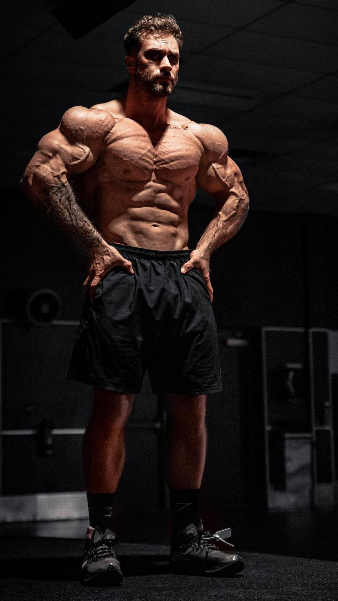 Chris Bumstead, dimly lit gym, dramatic lighting, Full HD Phone Wallpaper