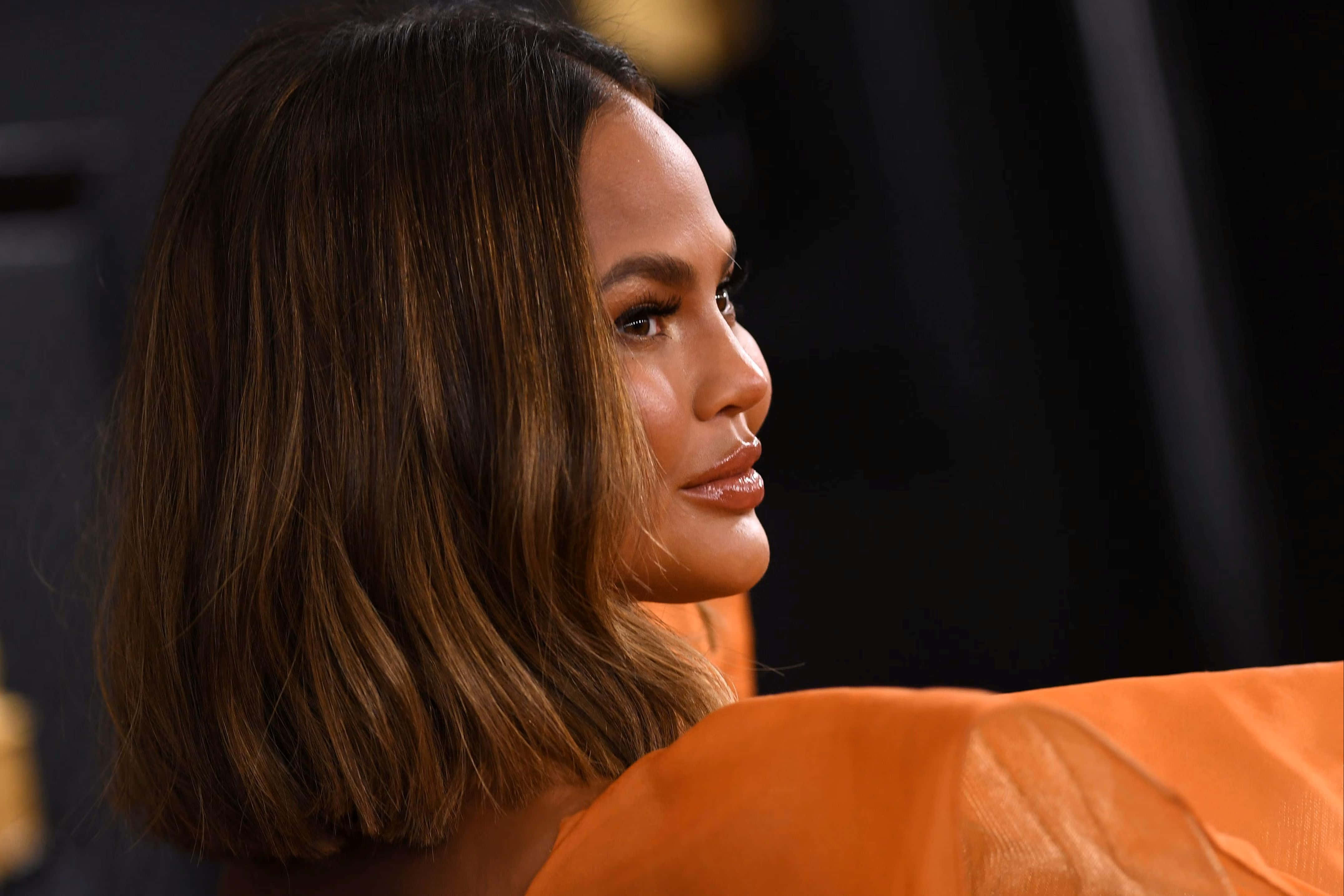 Chrissy Teigen, orange dress, shoulder-length brown hair, 4K Desktop Wallpaper