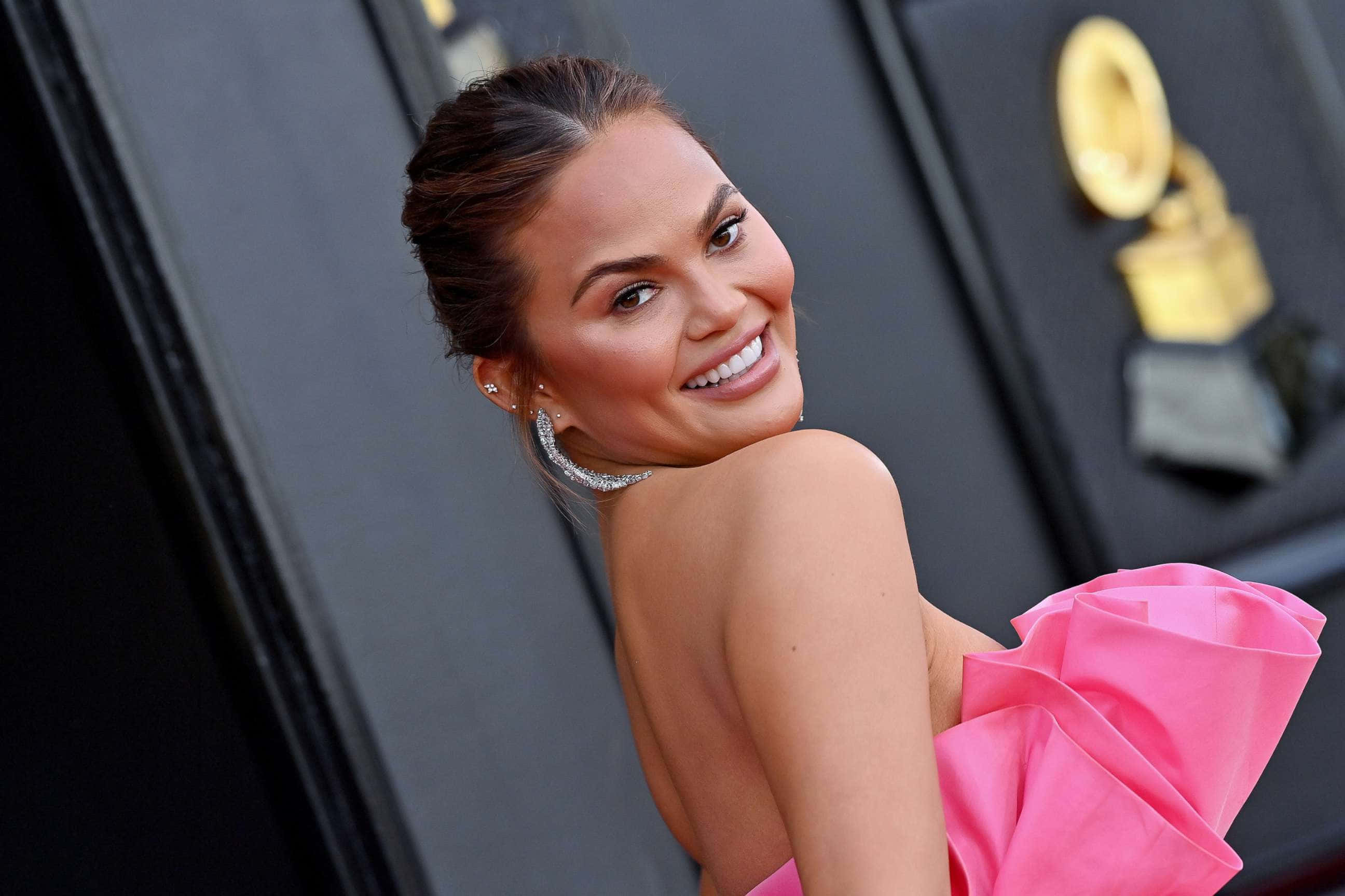 Chrissy Teigen, vibrant pink gown, glamorous awards event, 2K Desktop Wallpaper