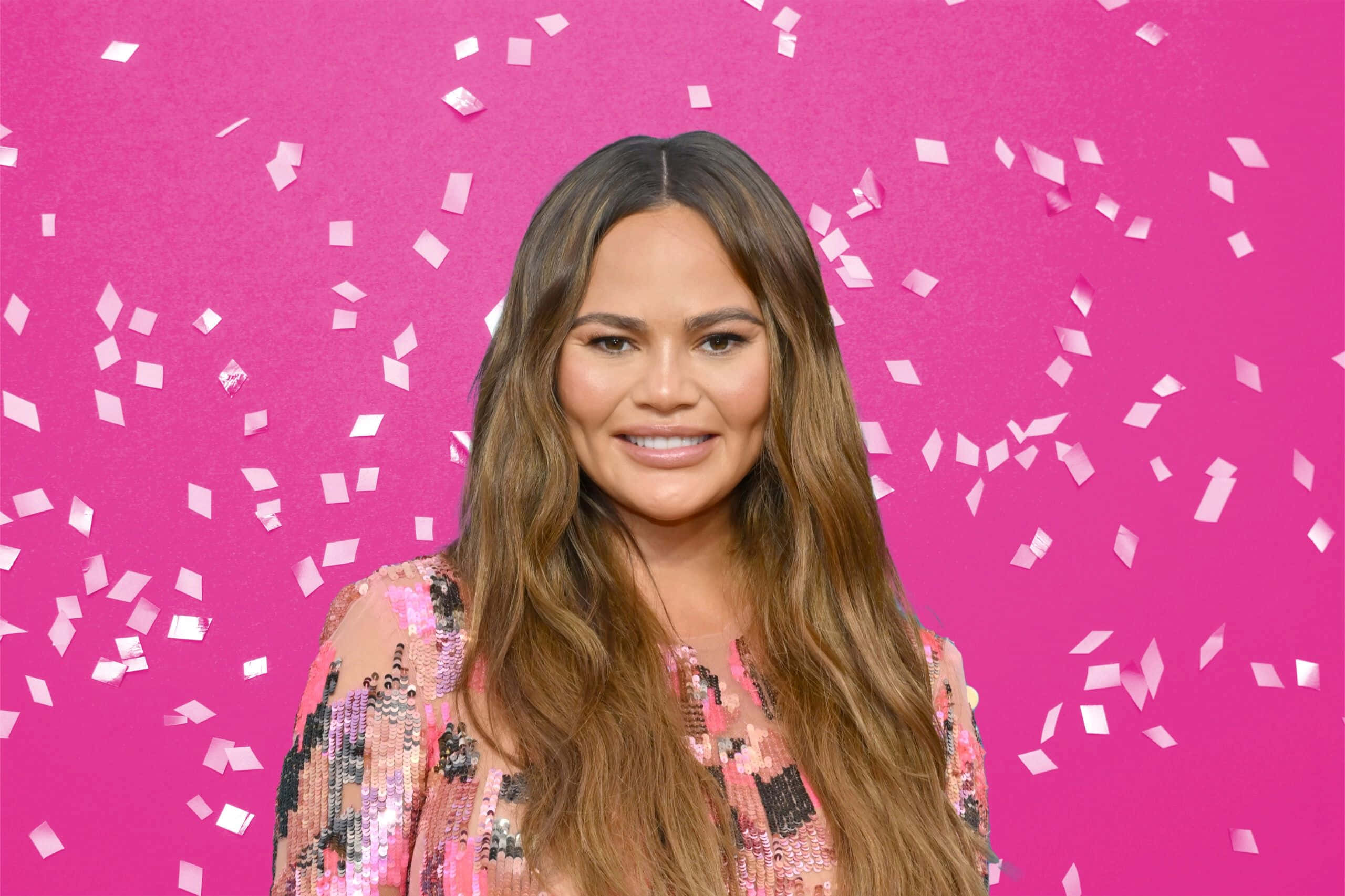 Chrissy Teigen, pink backdrop, white confetti, 2K Desktop Wallpaper