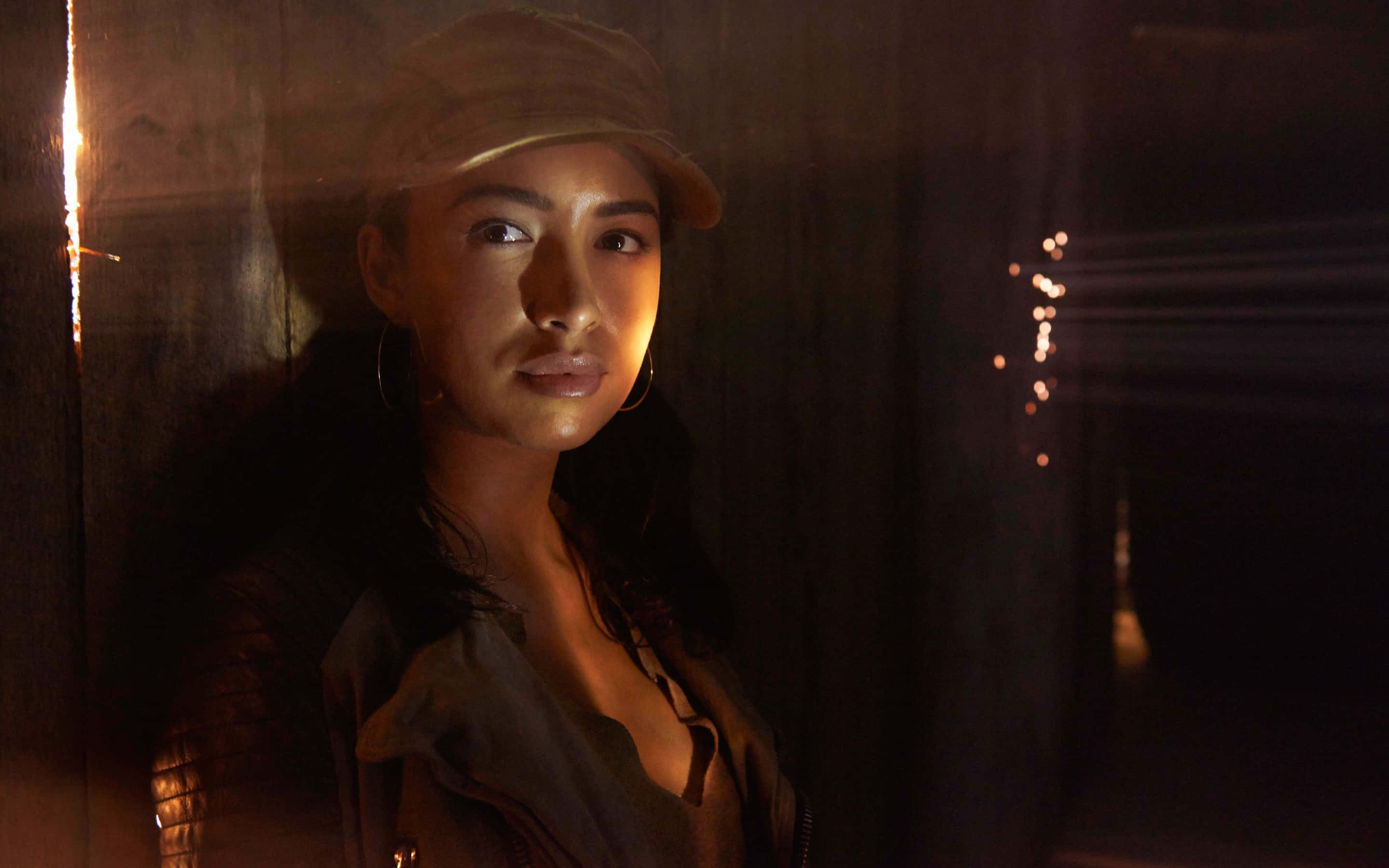 Christian Serratos, cap, dimly lit wooden room, 2K Desktop Wallpaper