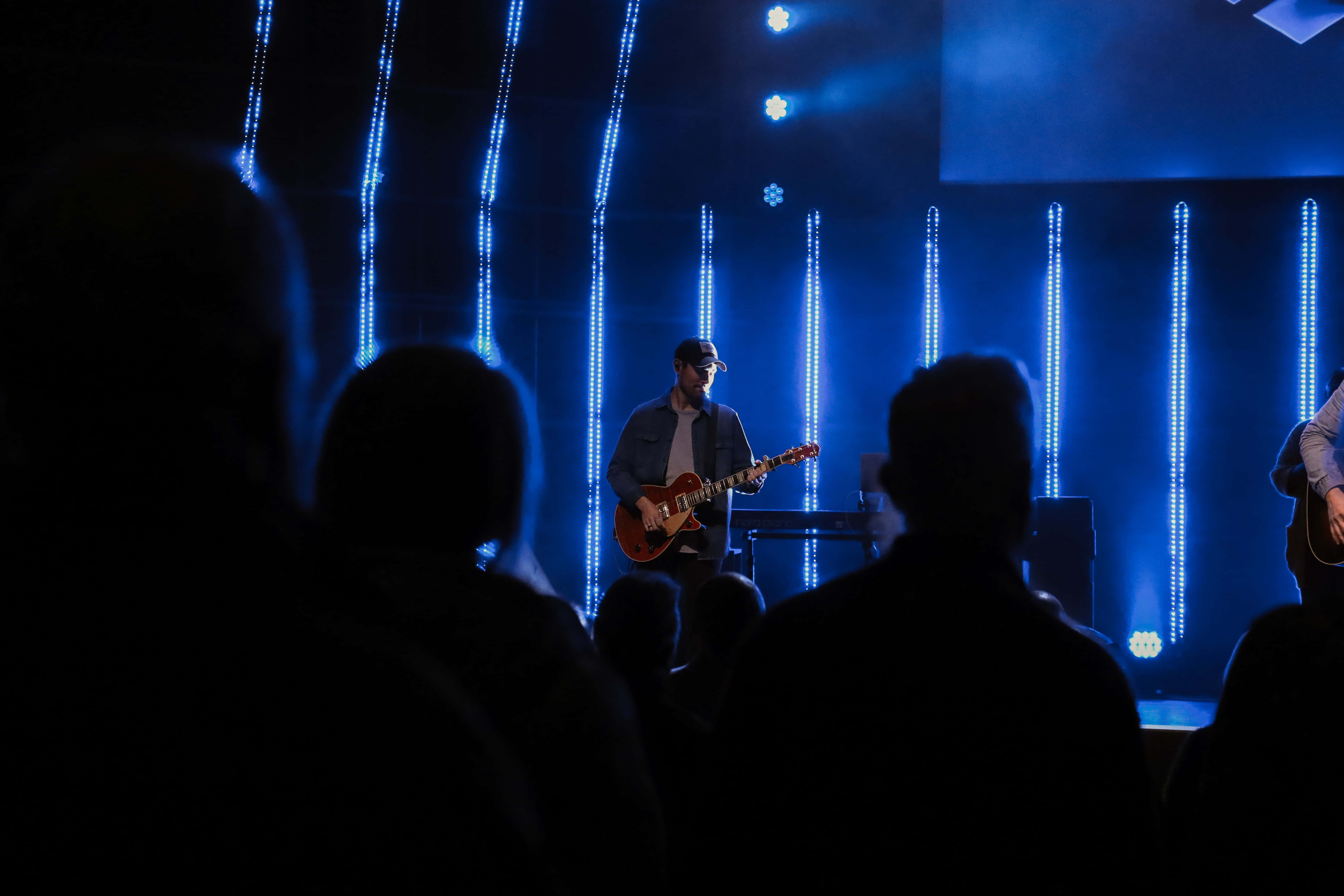 Worship Leader, electric guitar, dimly lit stage, 5K Desktop Wallpaper