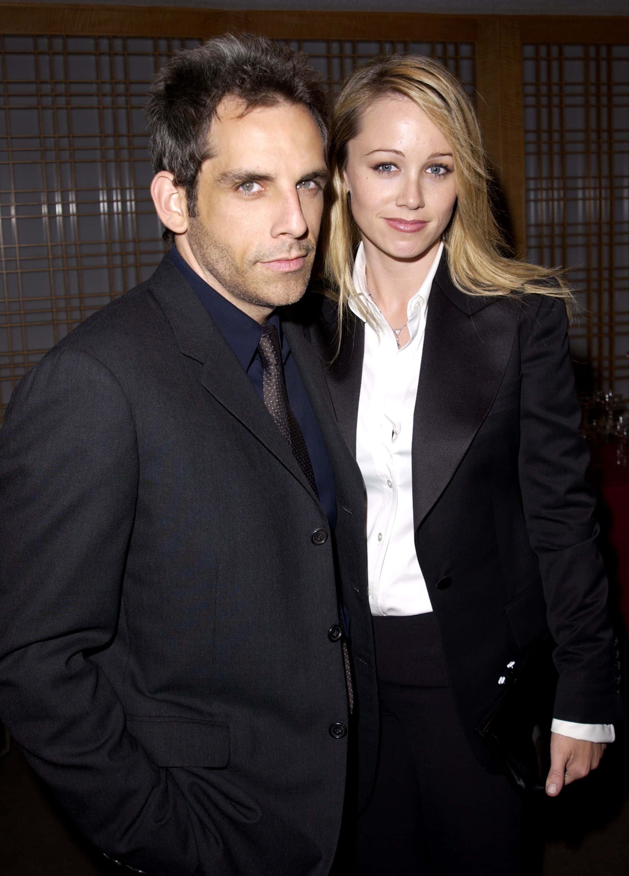 Christine Taylor, formal black suits, wooden lattice background, 2K Phone Wallpaper