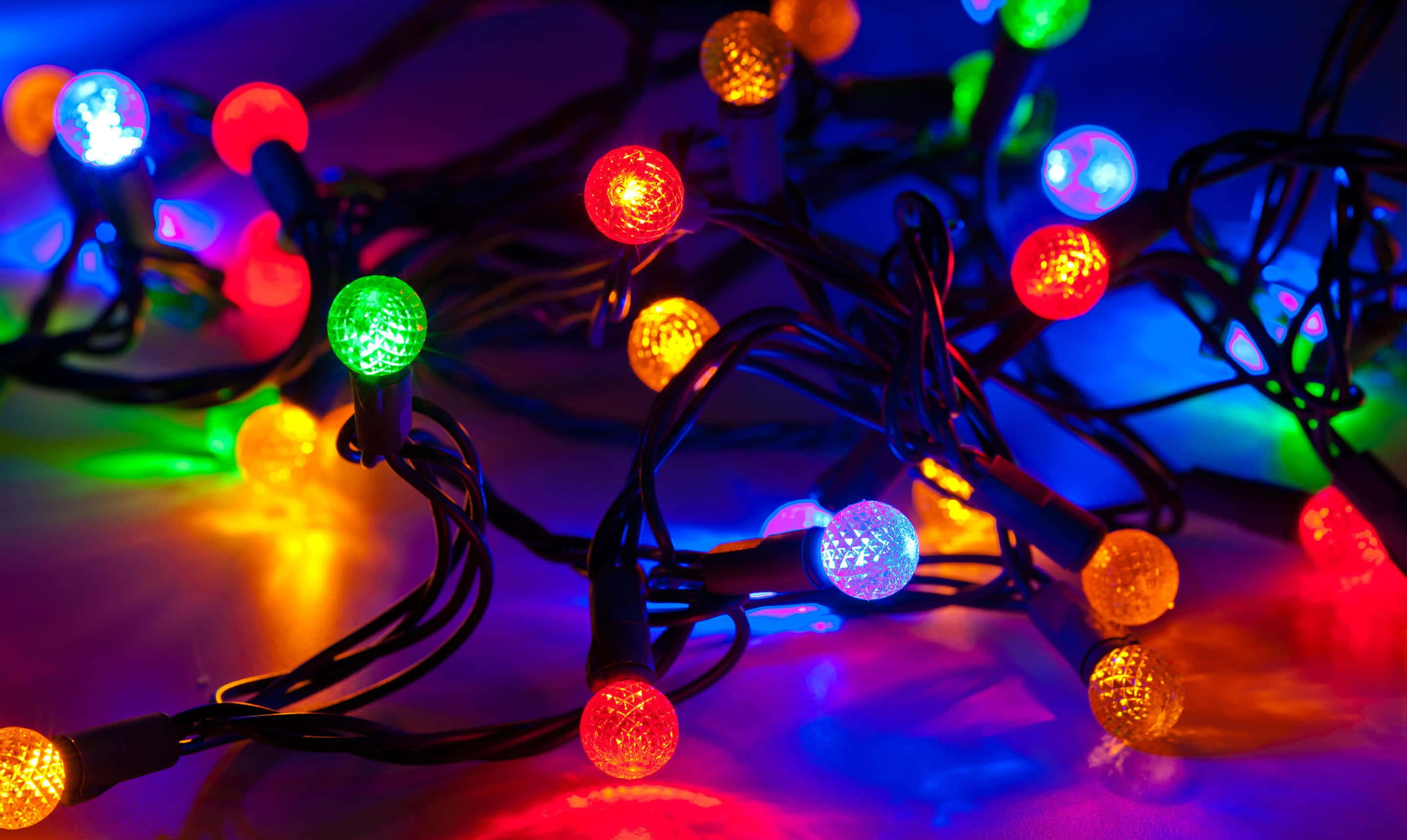 Christmas lights, glowing multicolored, dark surface, 2K Desktop Wallpaper