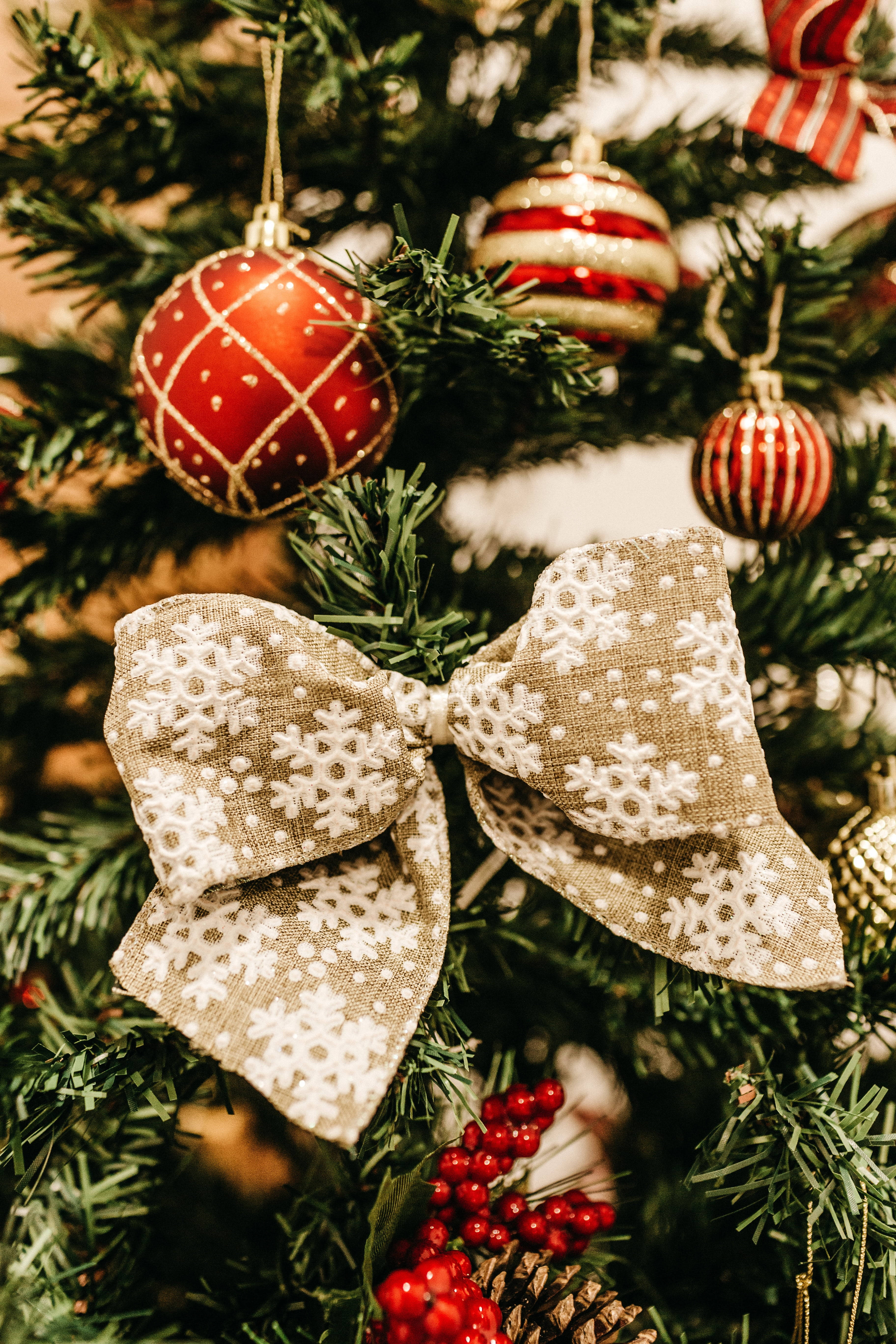 Christmas tree, rustic snowflake-patterned bow, red ornaments, 5K Phone Wallpaper