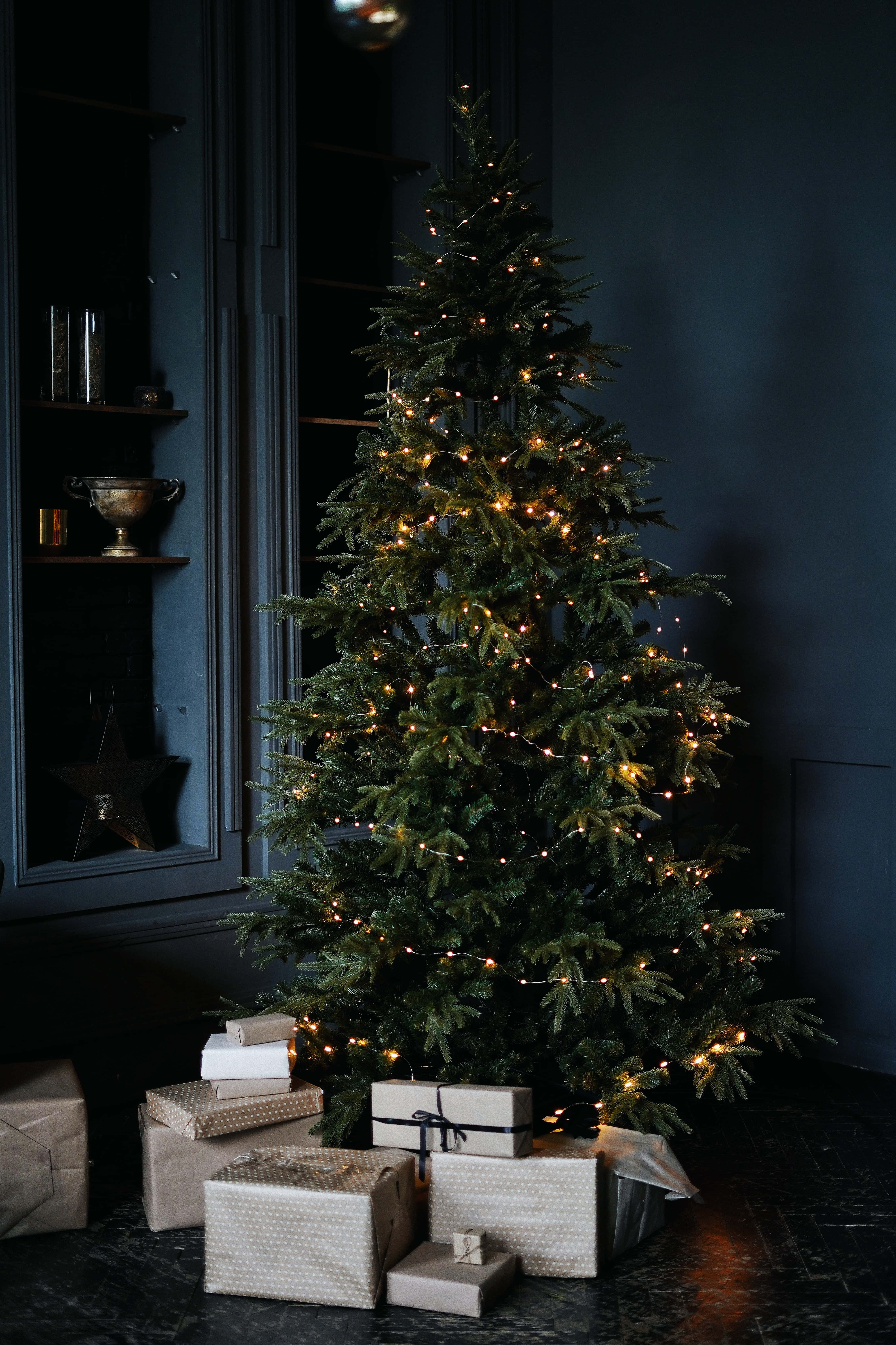 Christmas tree, warm string lights, dark blue cabinet, 5K Phone Wallpaper