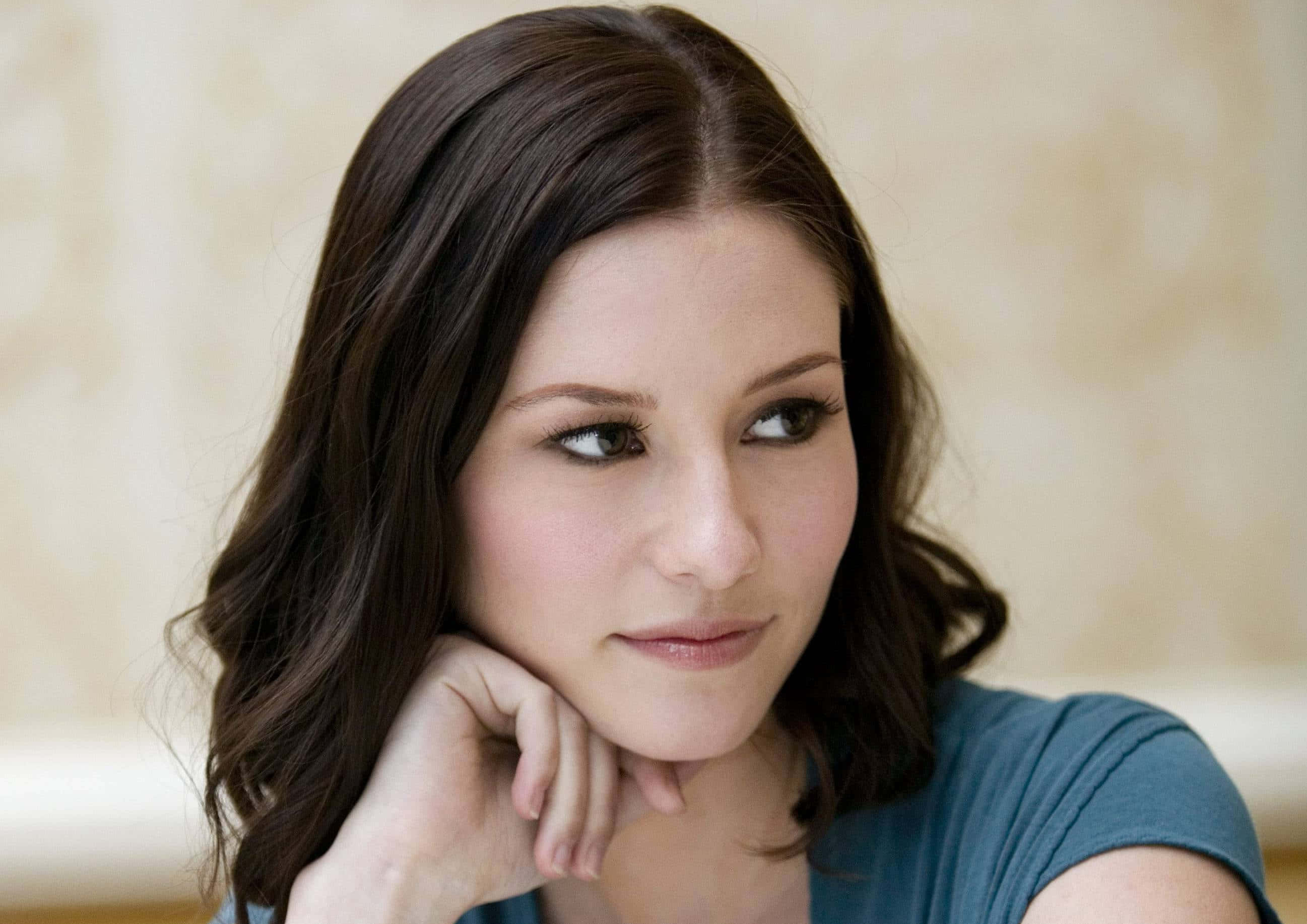Chyler Leigh, dark wavy hair, soft beige textured wall, 2K Desktop Wallpaper