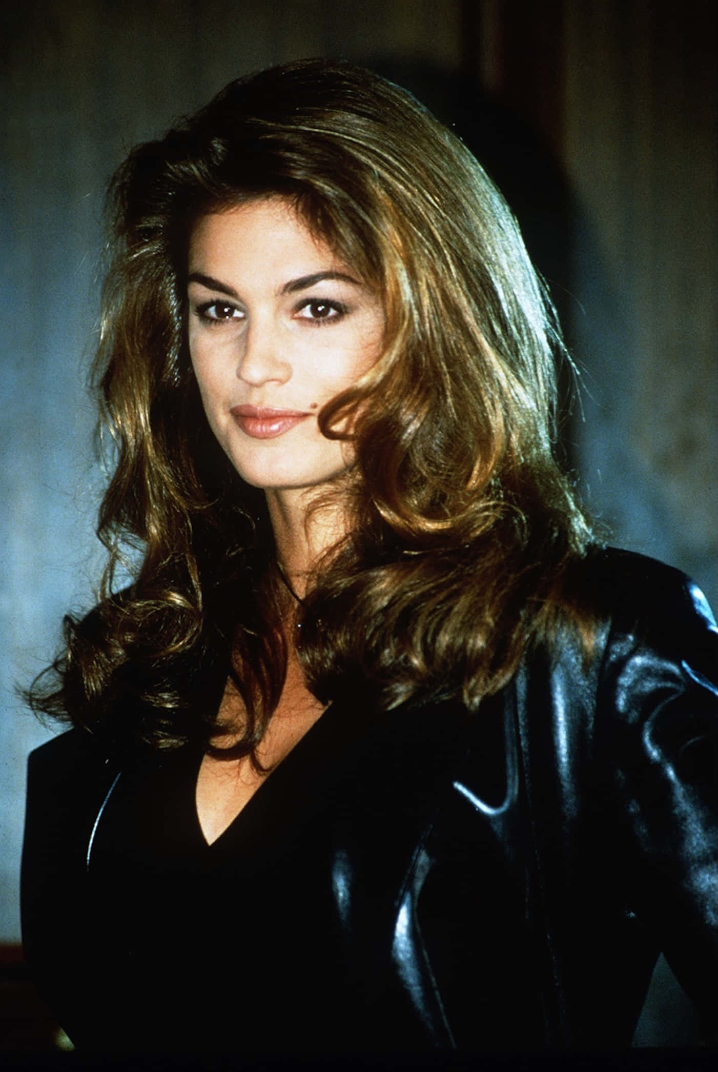 Cindy Crawford, shiny black leather jacket, muted blue-gray backdrop, Full HD Phone Wallpaper