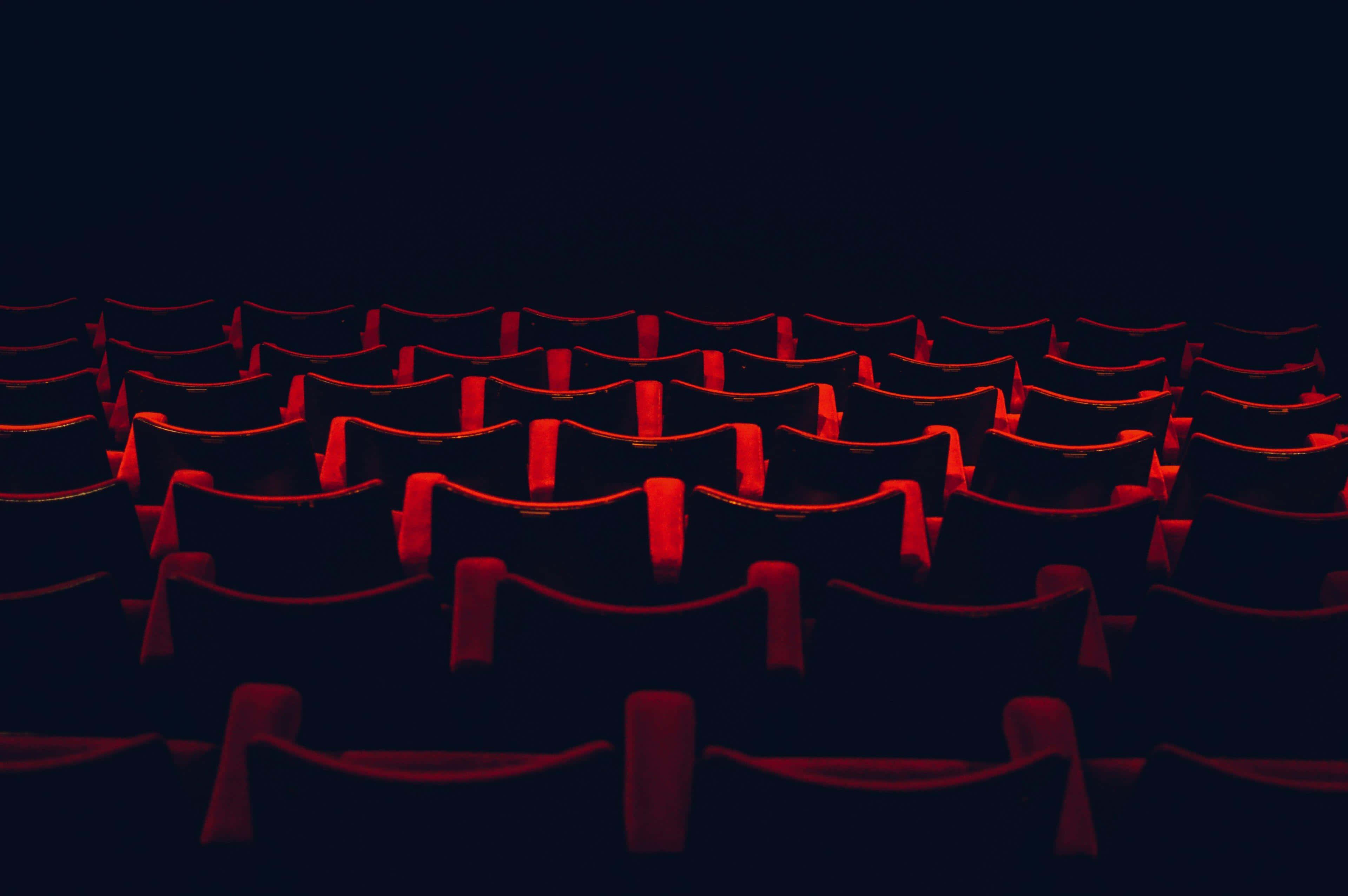 red theater seats, dark theater, ambient lighting, 4K Desktop Wallpaper