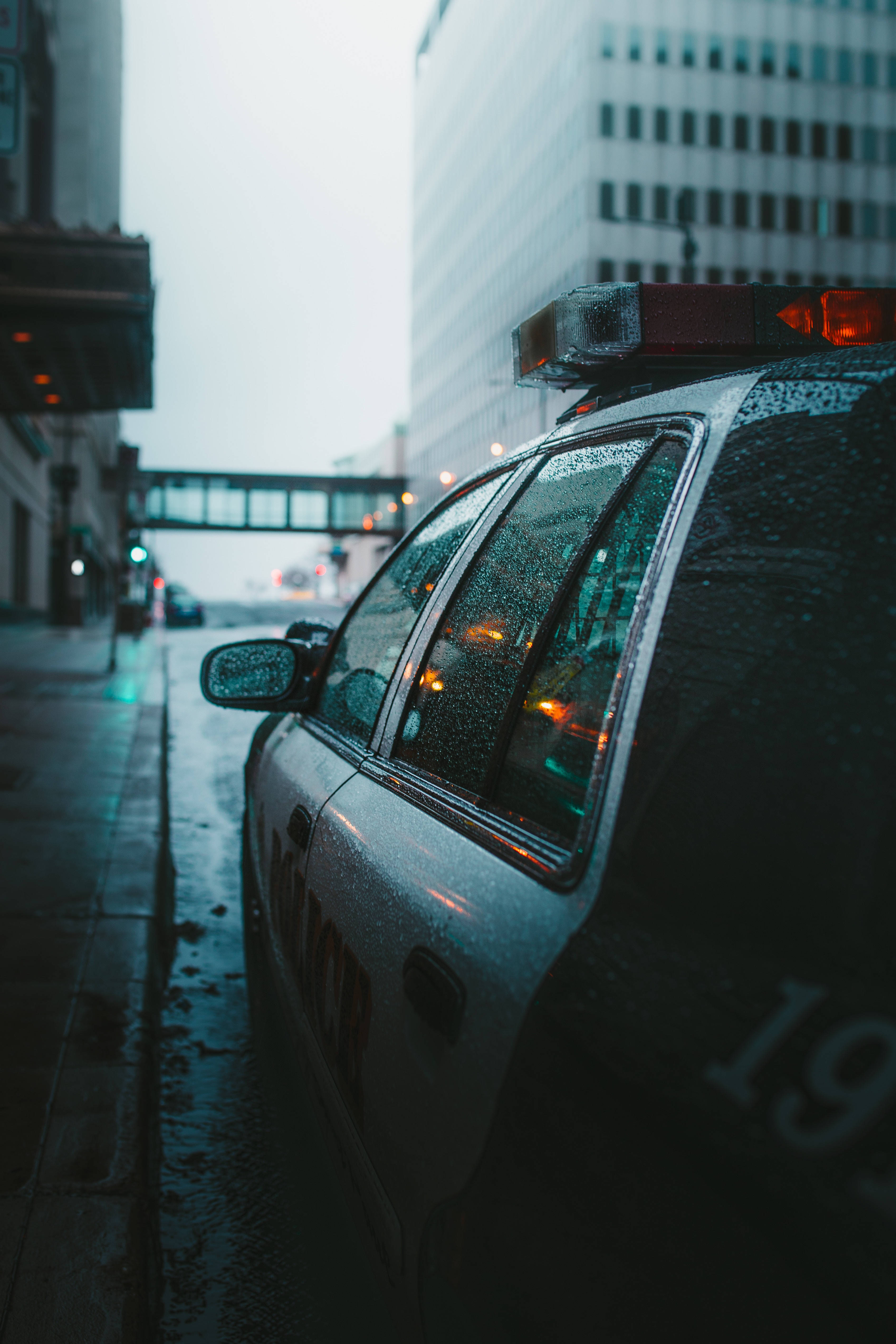 police car, rain-slicked, wet city street, 4K Phone Wallpaper