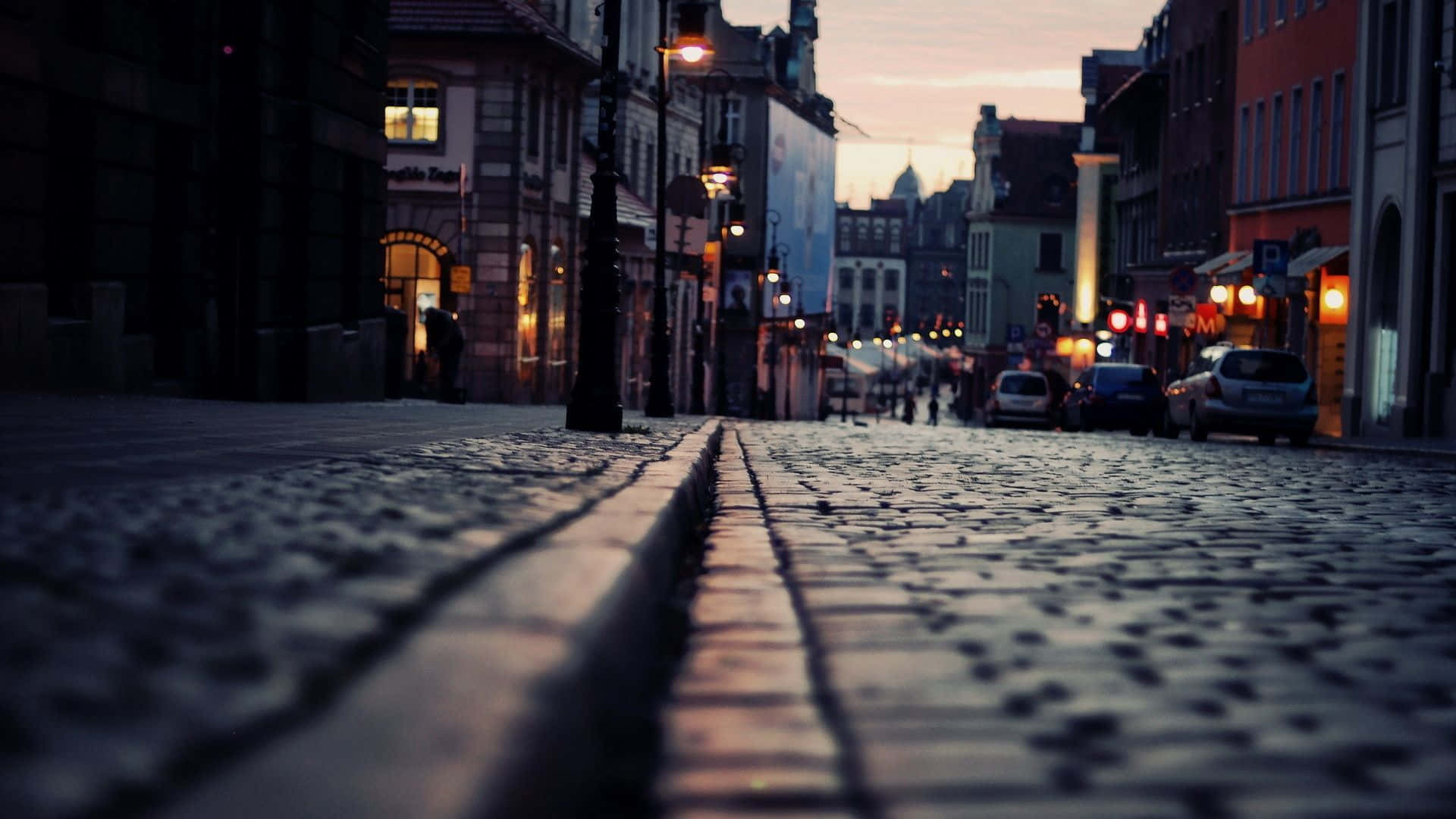Cobblestone street, twilight cityscape, warm glowing lights, Full HD Desktop Wallpaper