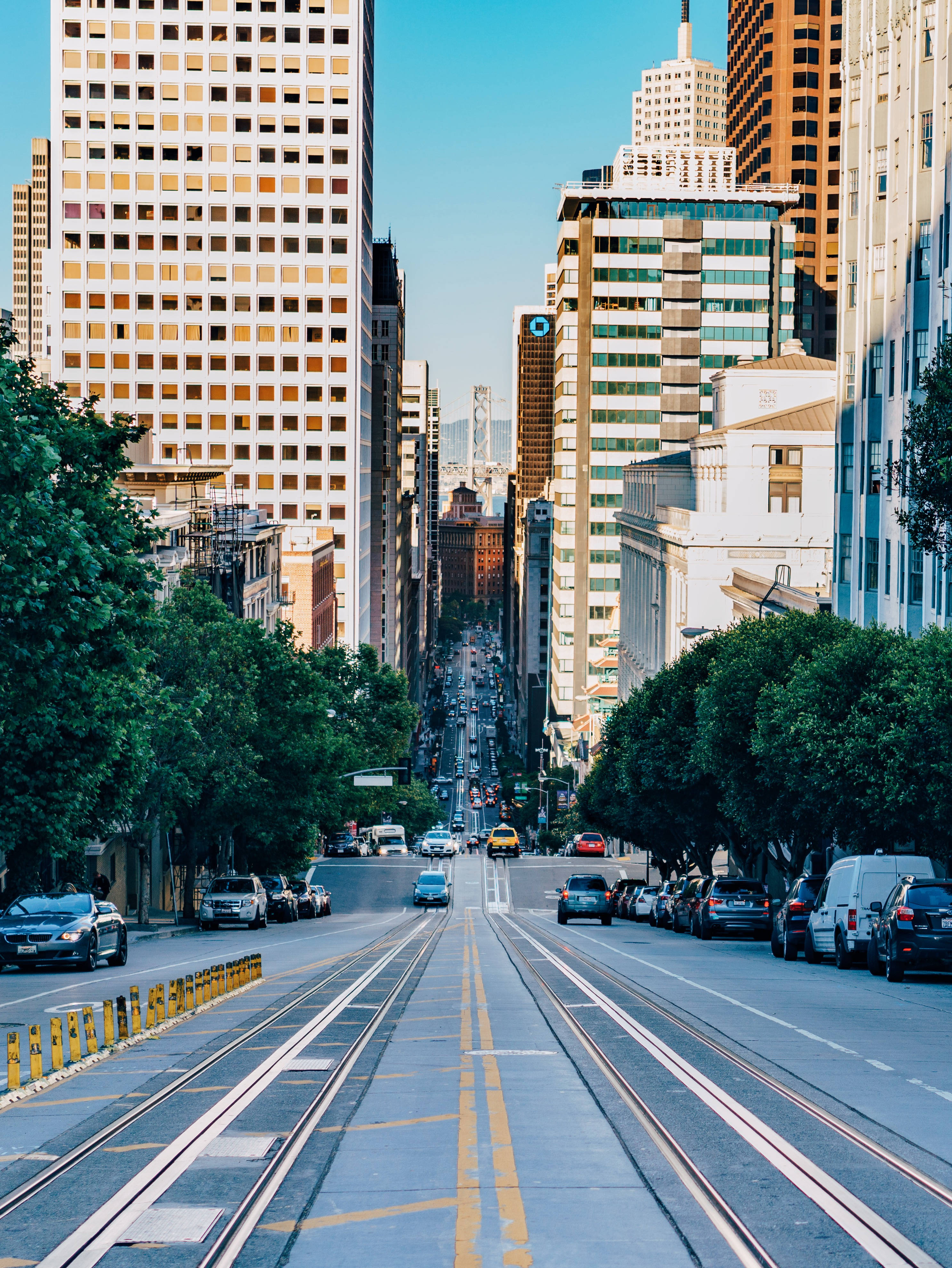 Sunny Downhill Street, urban street, tall buildings, 4K Phone Wallpaper