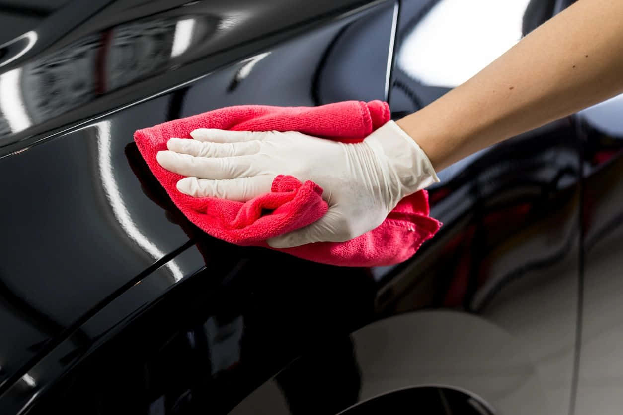 gloved hand, glossy black car surface, vibrant red microfiber cloth, SD Desktop Wallpaper