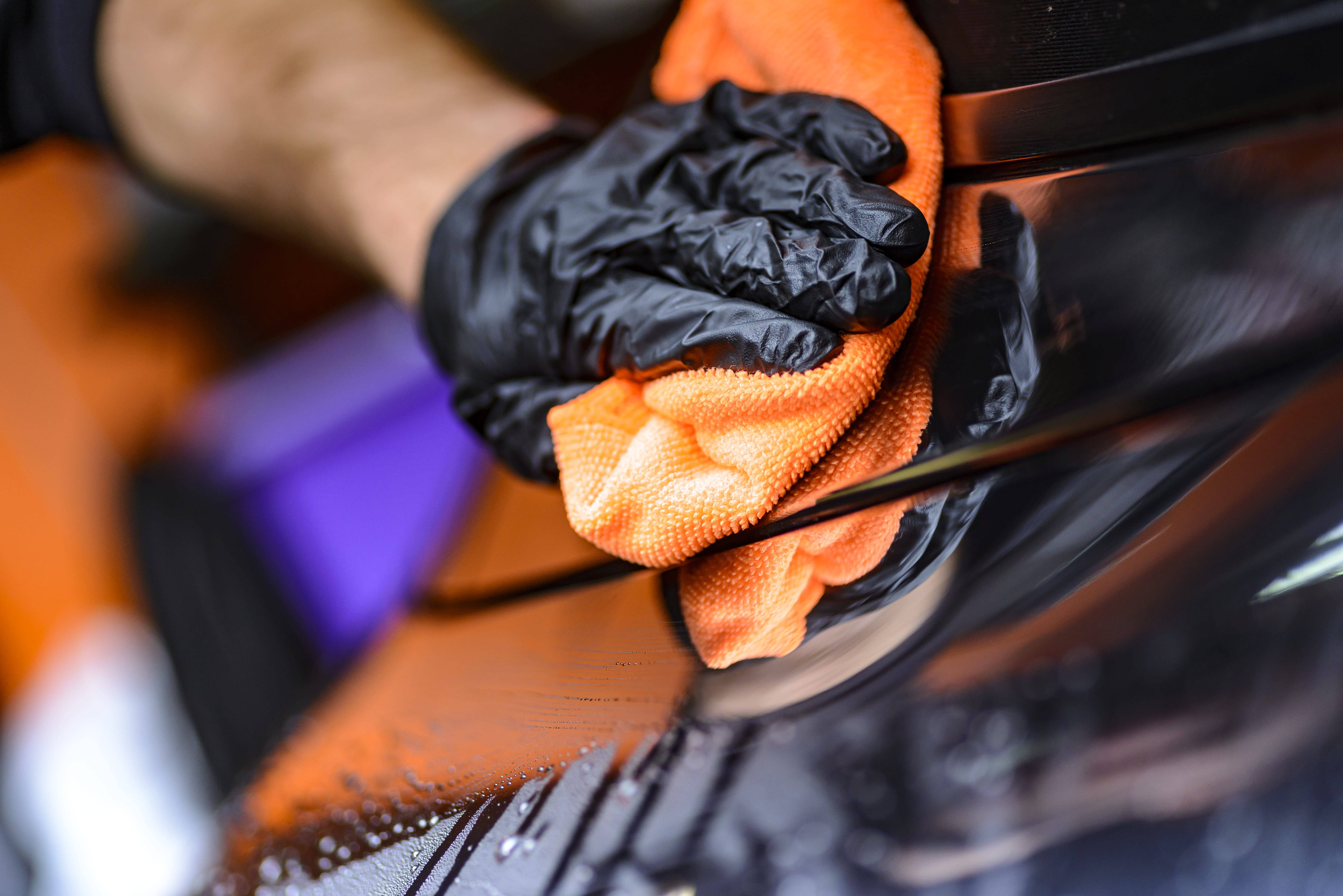 orange microfiber cloth, gloved hand, glossy black car surface, 5K Desktop Wallpaper