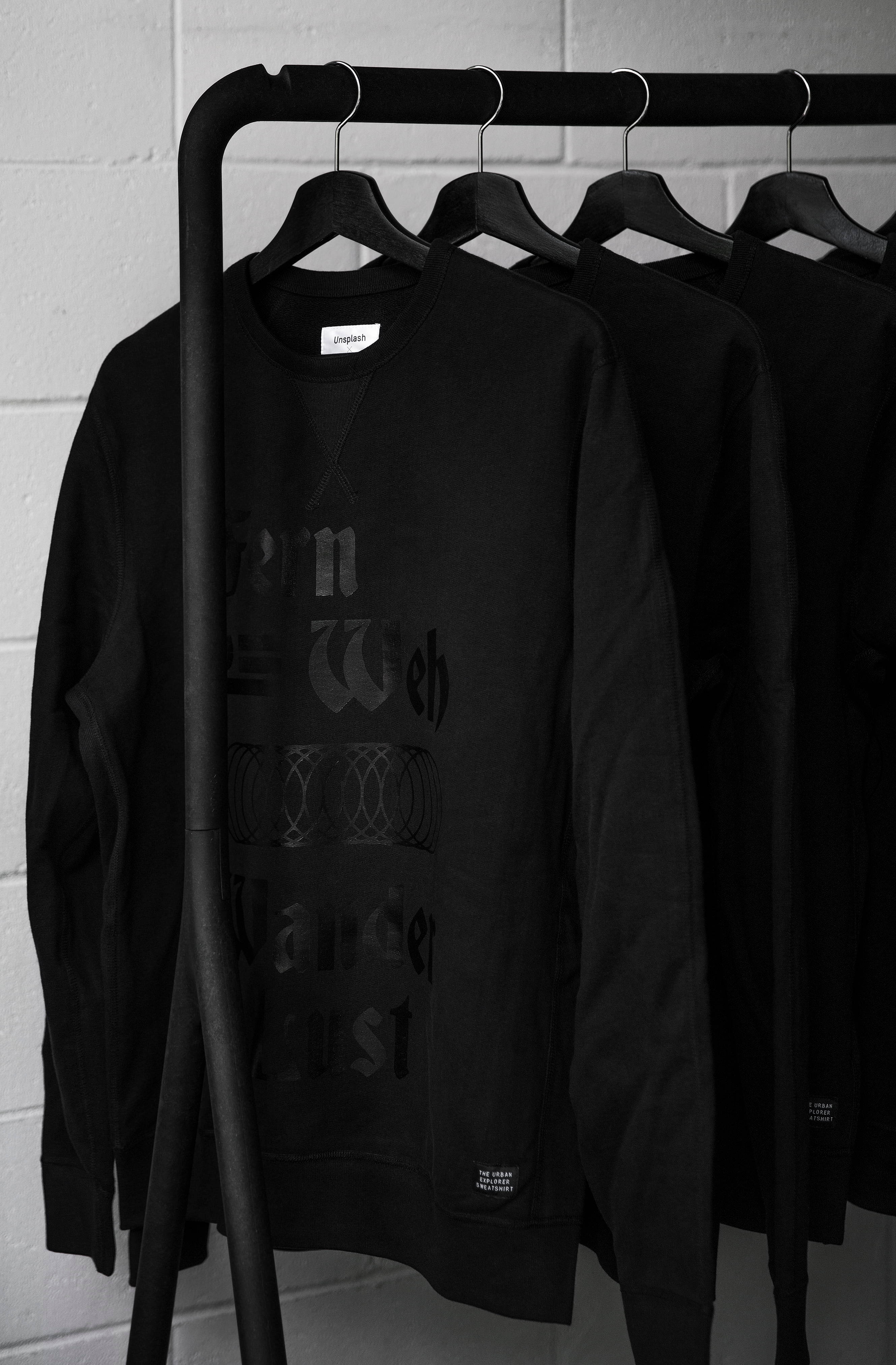 black sweatshirts, subtle gray text, black metal rack, 4K Phone Wallpaper