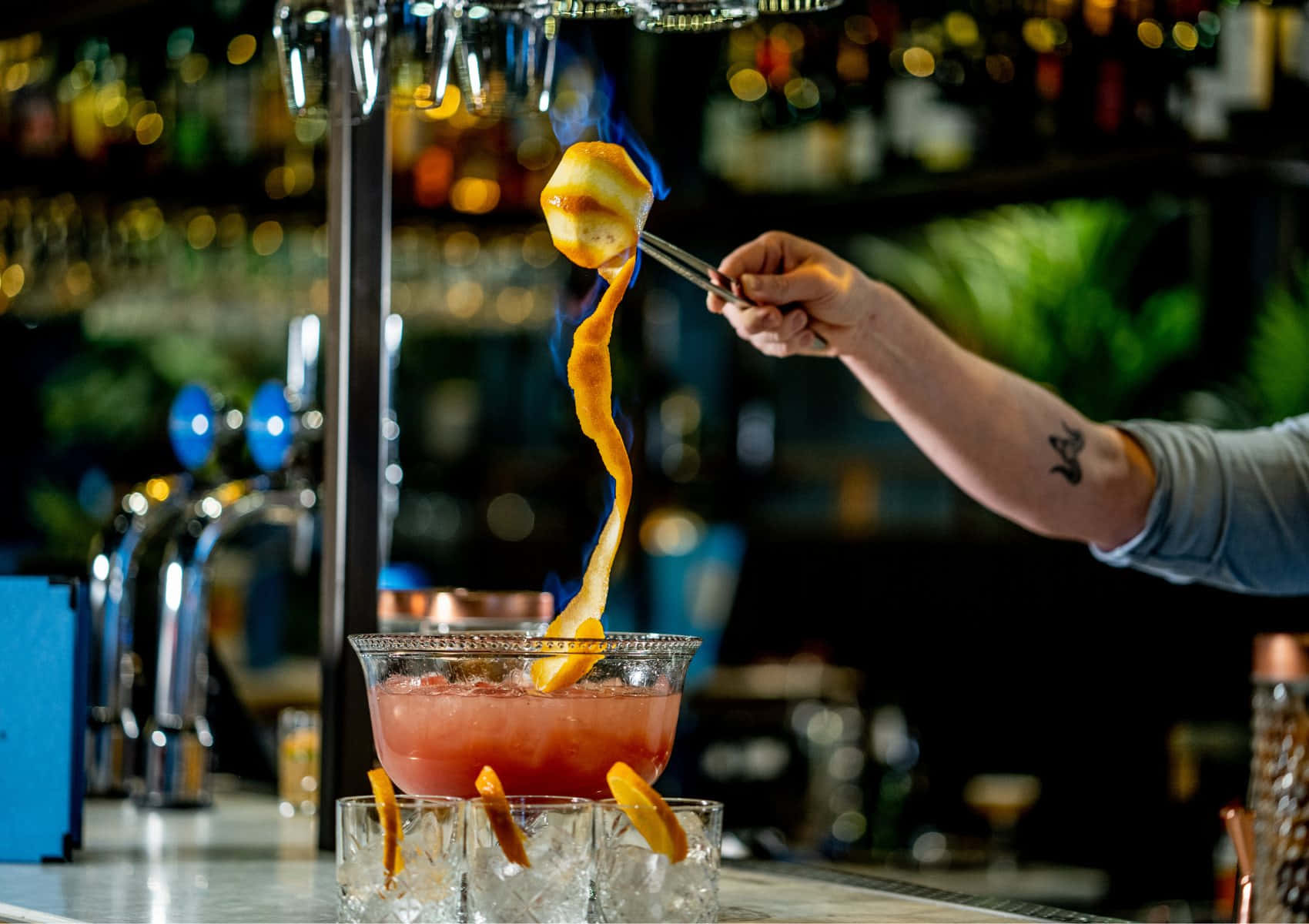 flambeing an orange peel, vibrant pink cocktail, dimly lit bar, HD Desktop Wallpaper