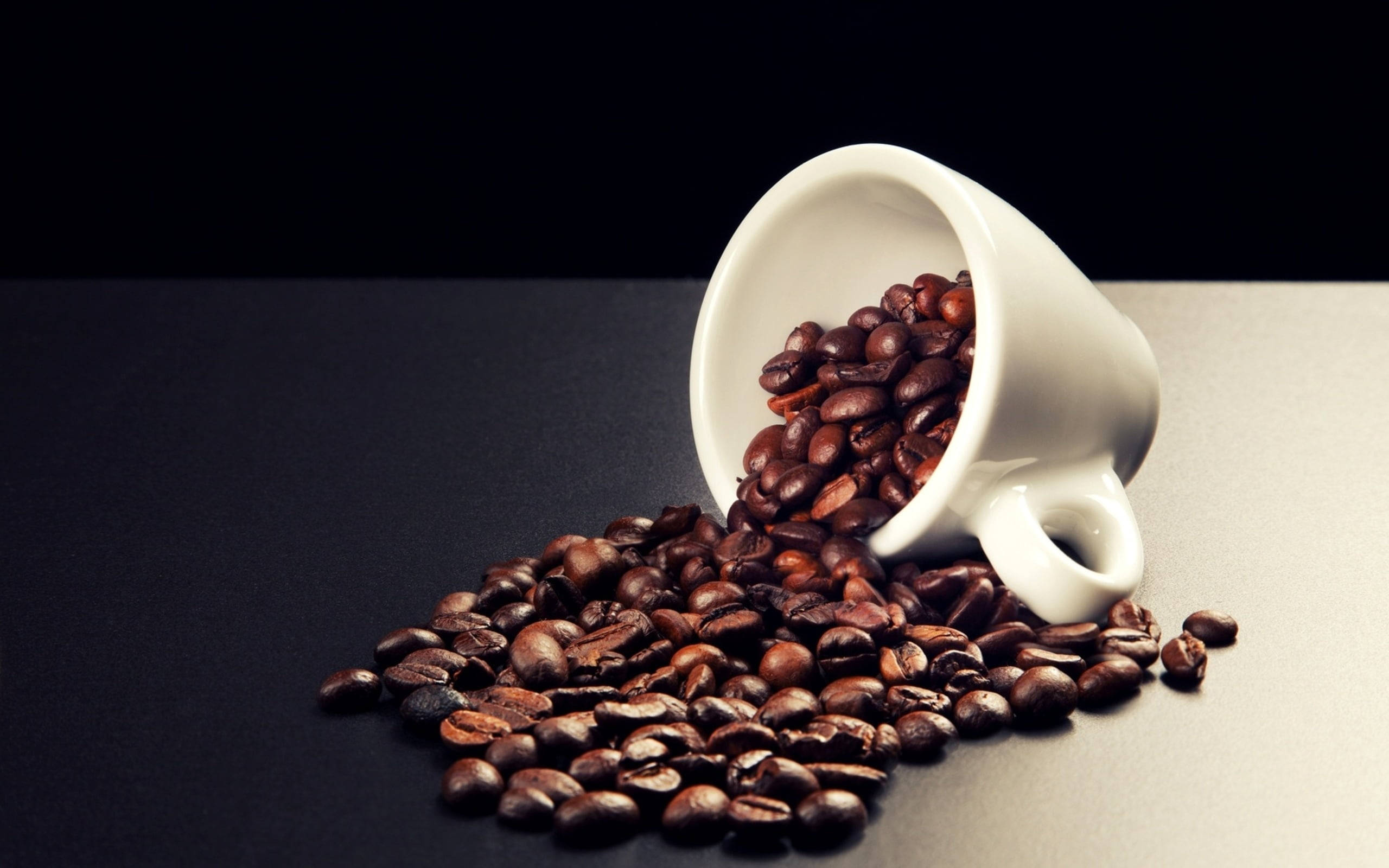 white ceramic mug, glossy dark brown coffee beans, sleek black and gray surface, 2K Desktop Wallpaper