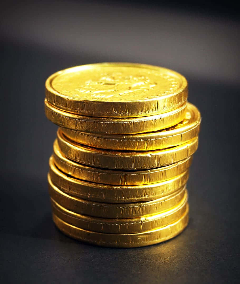 stacked gold coin cents, shiny gold-wrapped chocolate coins, soft light, SD Phone Wallpaper