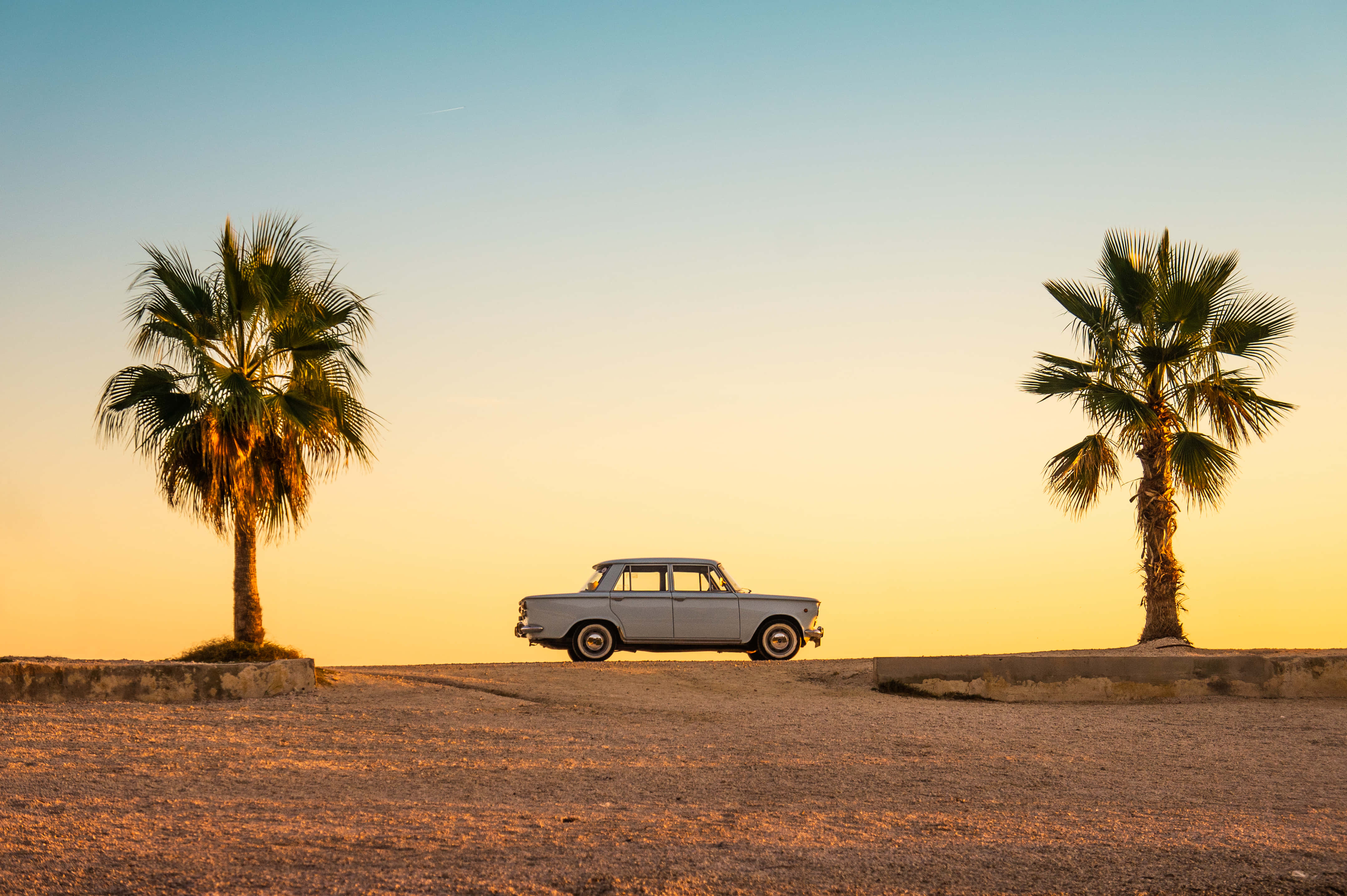 vintage silver car, palm trees, warm golden sunset sky, 4K Desktop Wallpaper