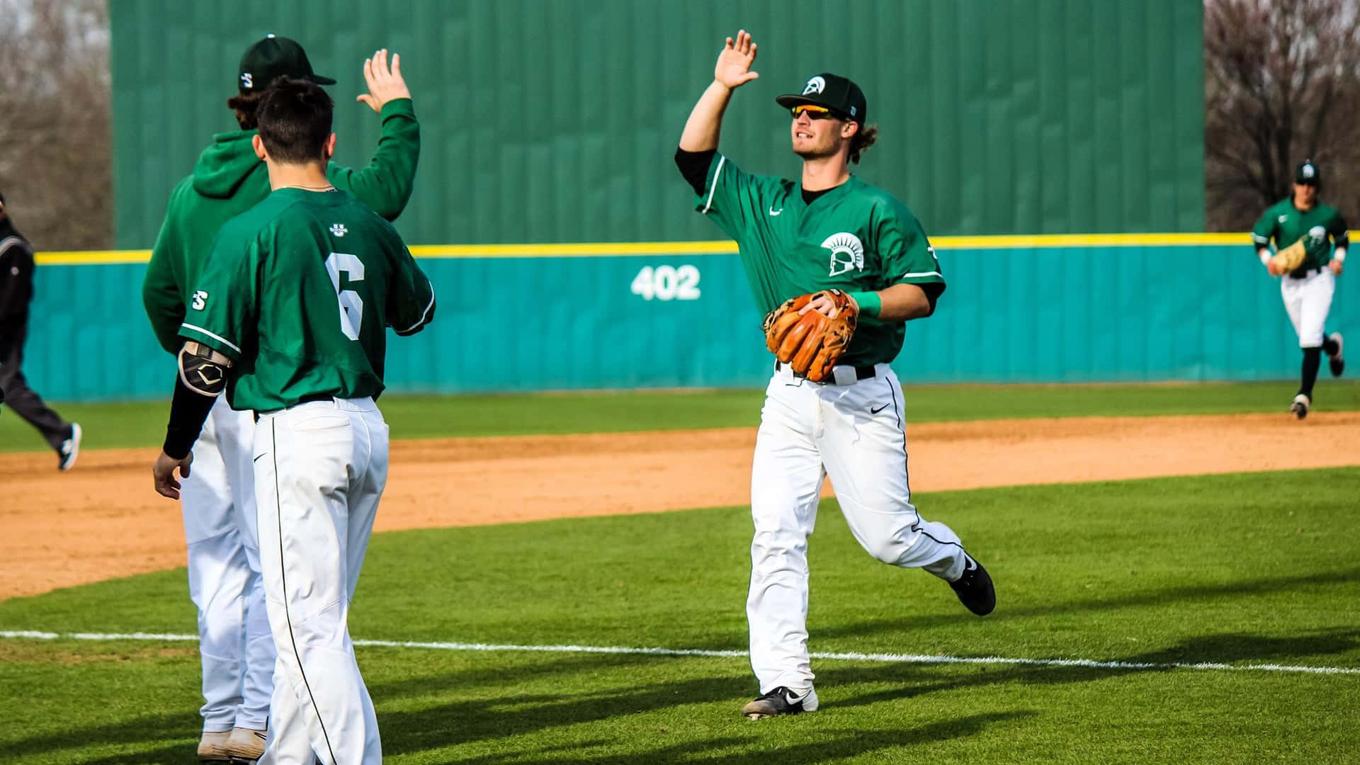 College Baseball, green jerseys, sunlit field, Full HD Desktop Wallpaper
