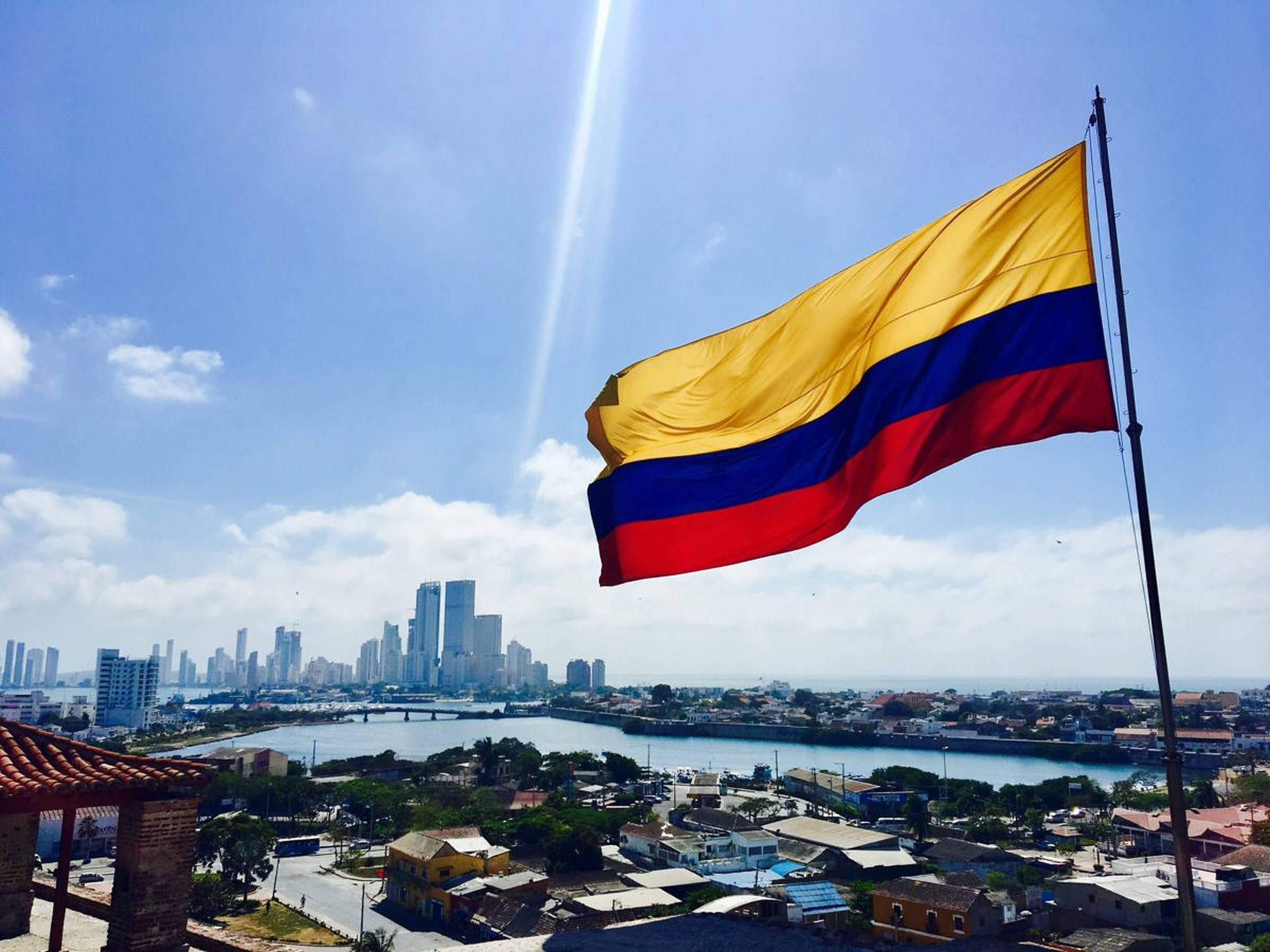 Colombia flag, bright blue sky, cityscape, Full HD Desktop Wallpaper