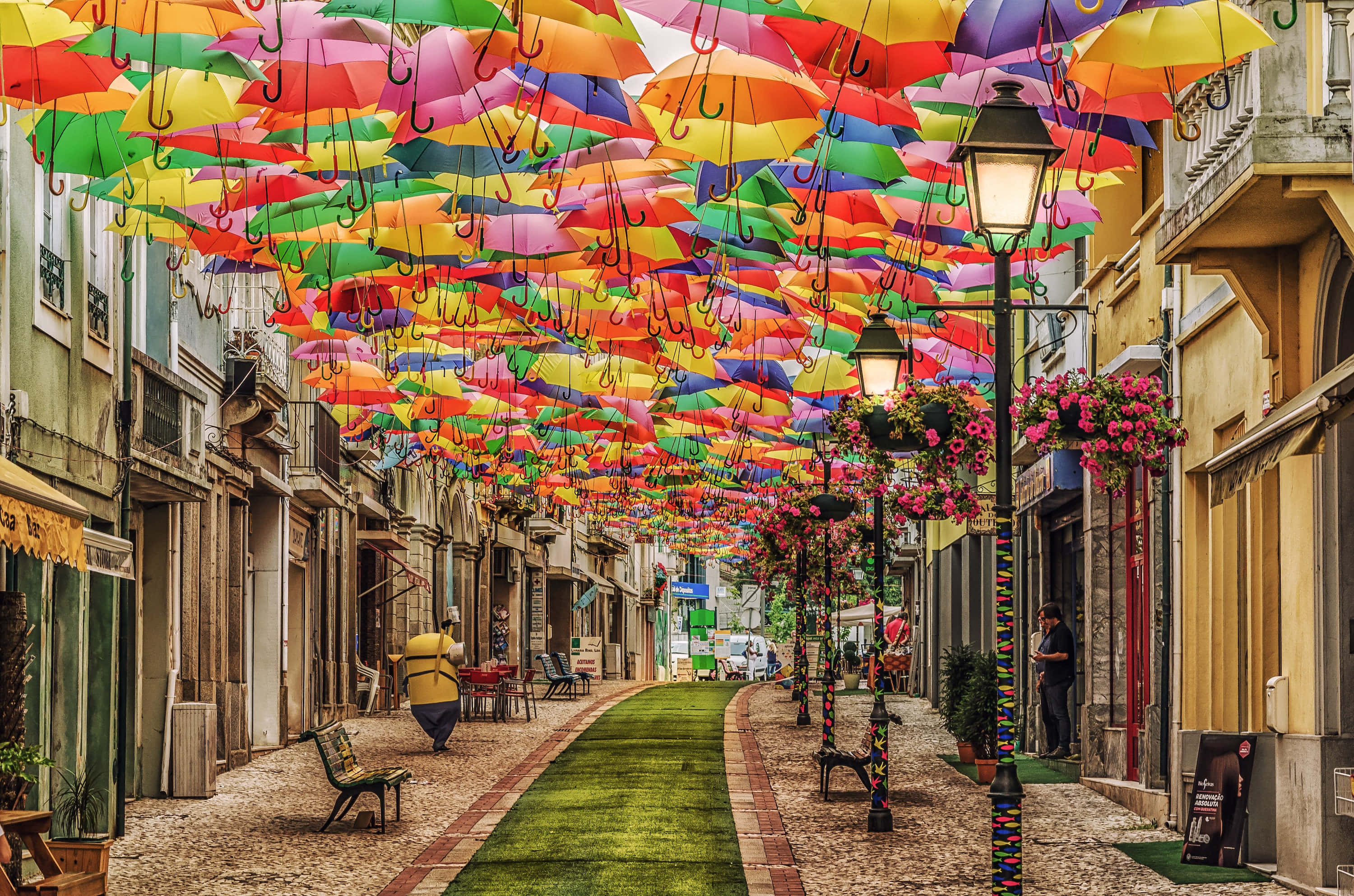 colorful umbrellas, cobblestone alley, hanging flowers, 2K Desktop Wallpaper
