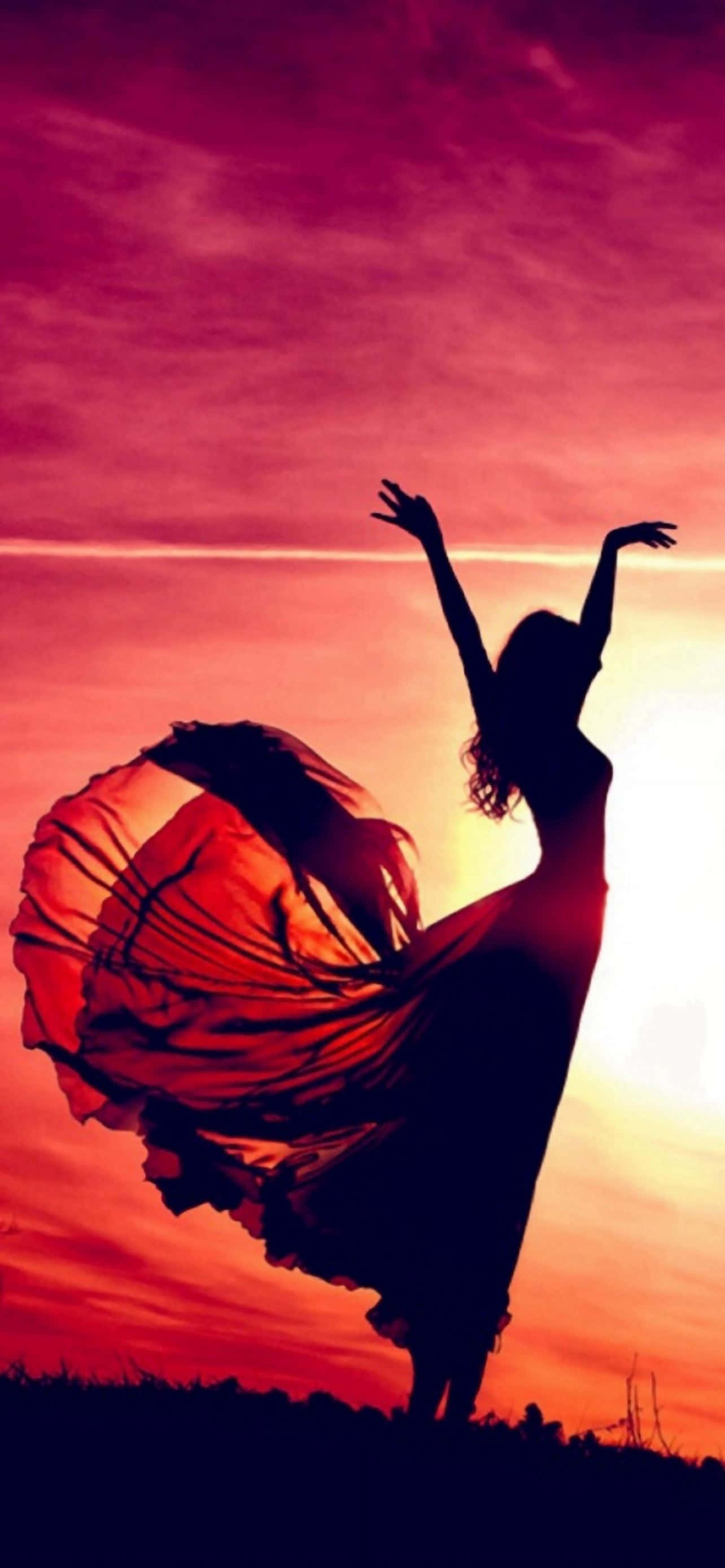 dancer's silhouette, fiery sunset sky, flowing red fabric, 2K Phone Wallpaper