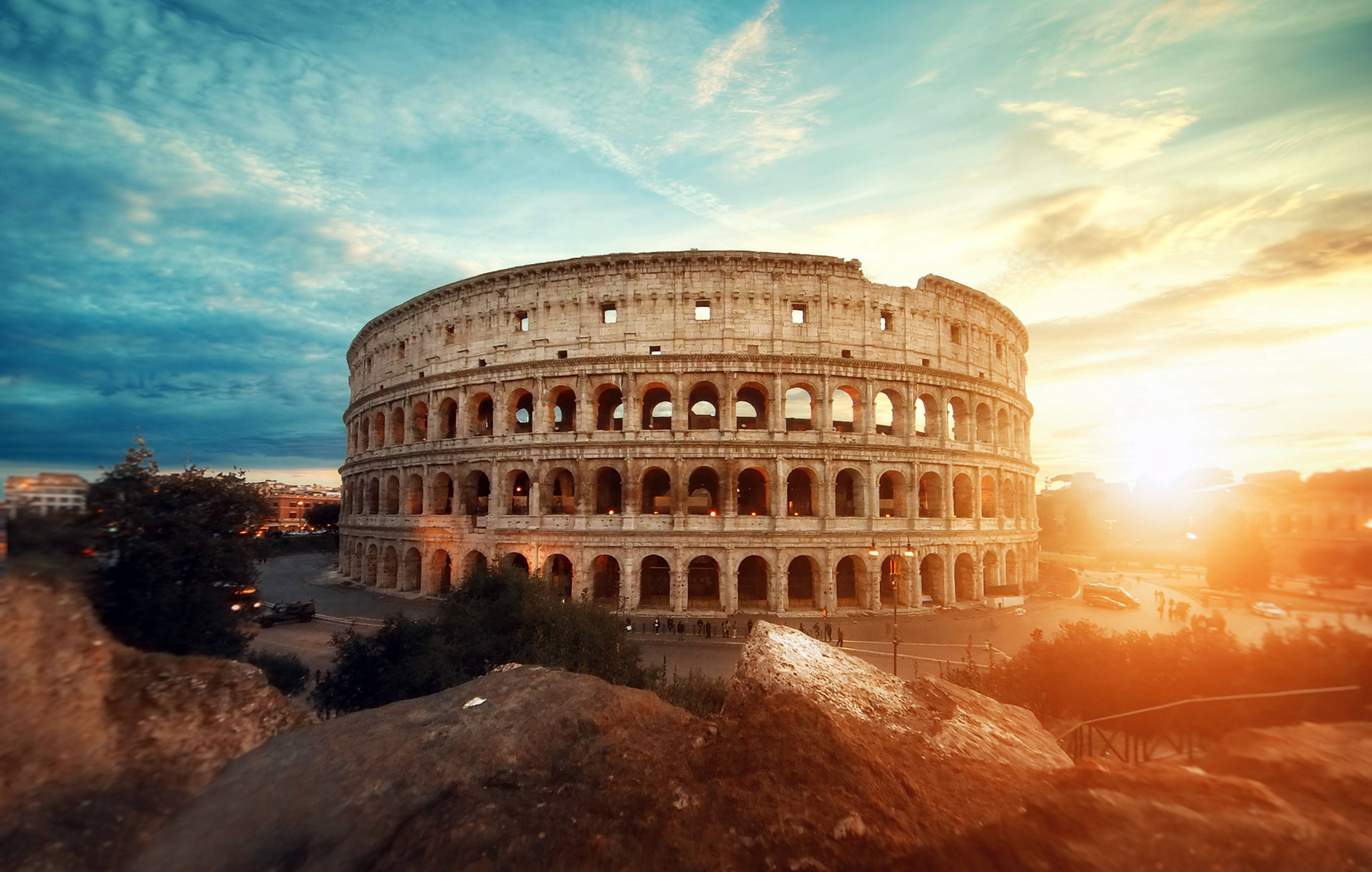 Colosseum, golden sunset light, dramatic clouds, 2K Desktop Wallpaper