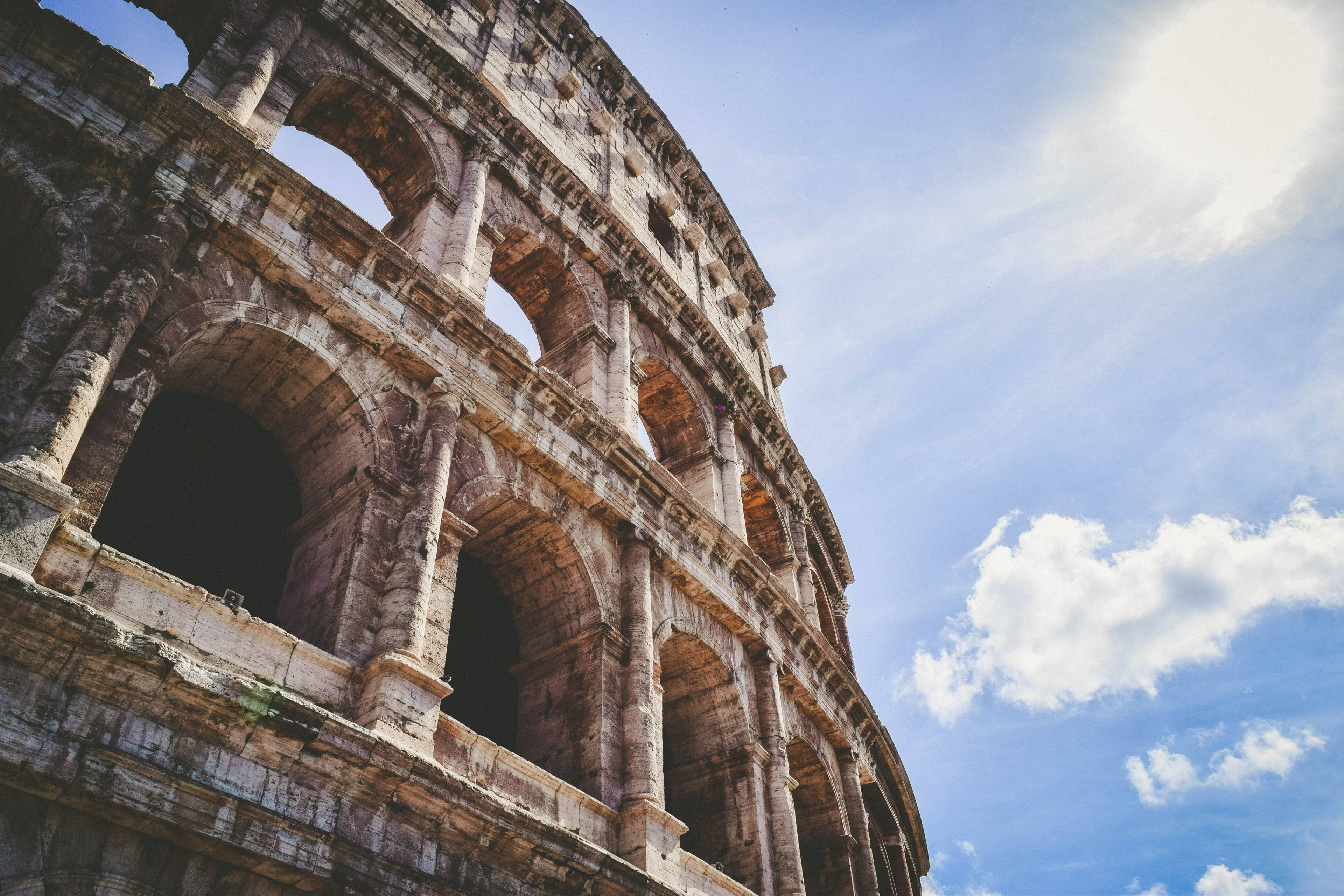 Colosseum, weathered stone arches, bright blue sky, 4K Desktop Wallpaper