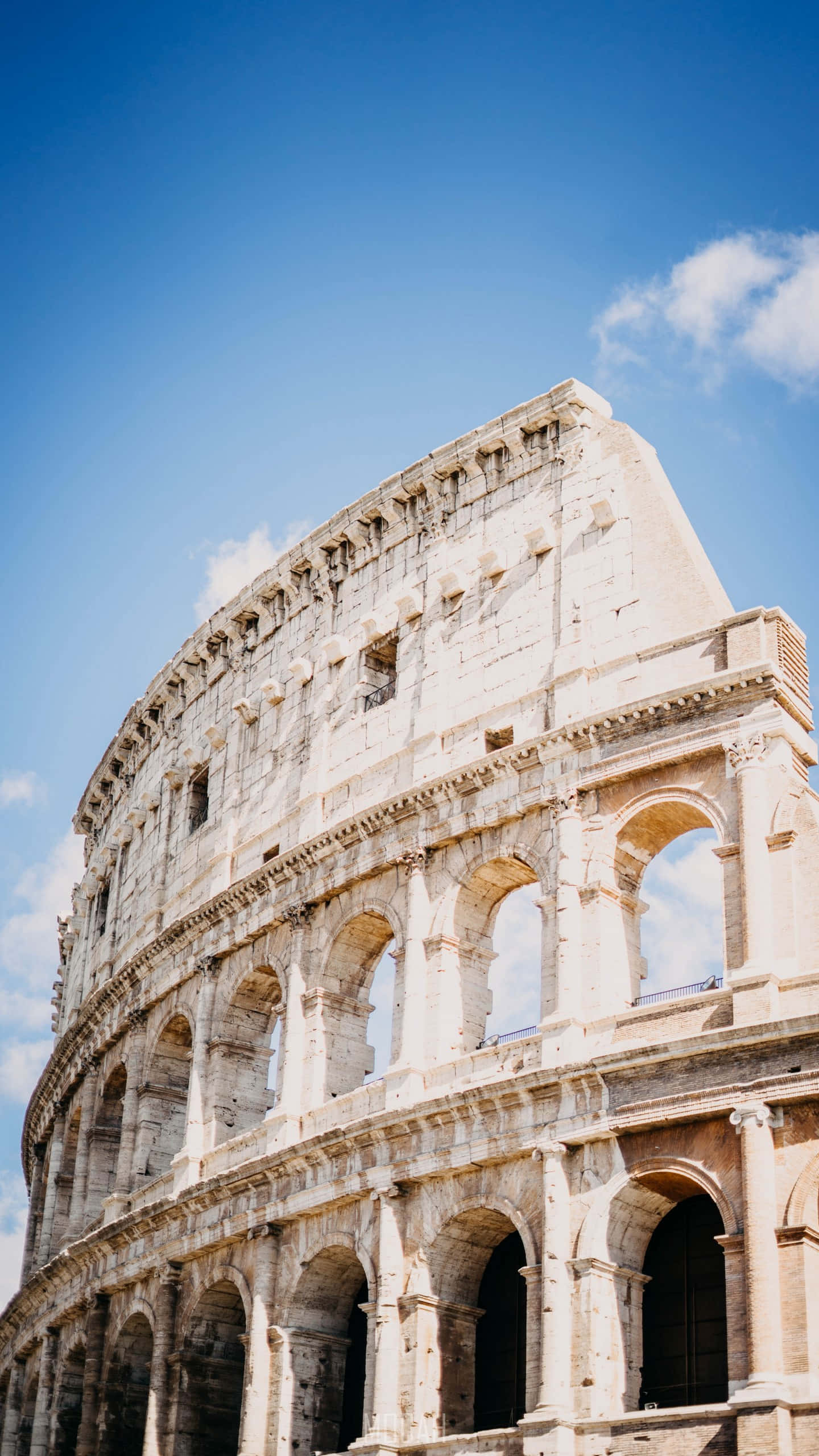 Colosseum, clear blue sky, scattered clouds, 2K Phone Wallpaper