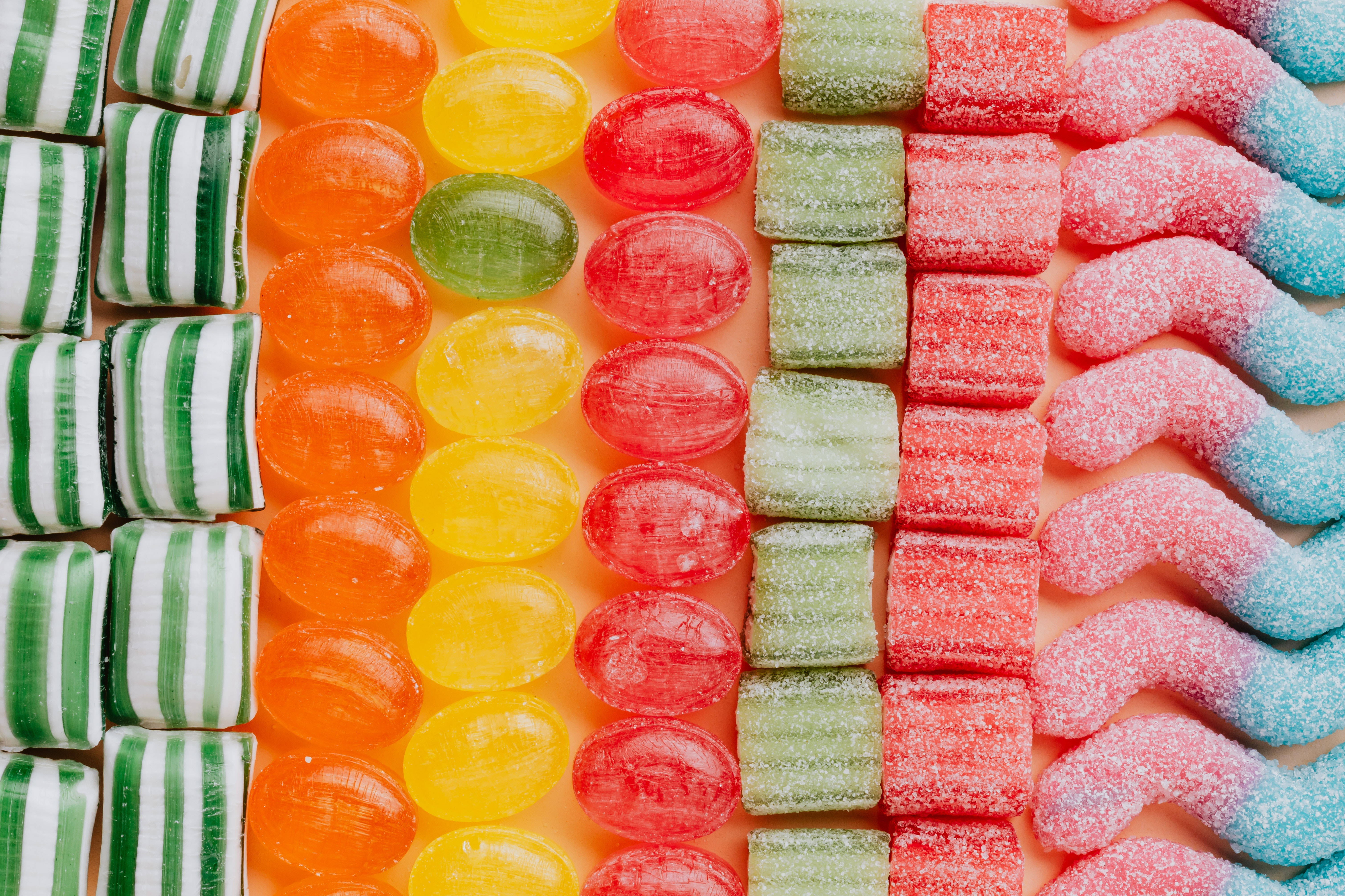 gummy candies, colorful rows, soft peach background, 5K Desktop Wallpaper