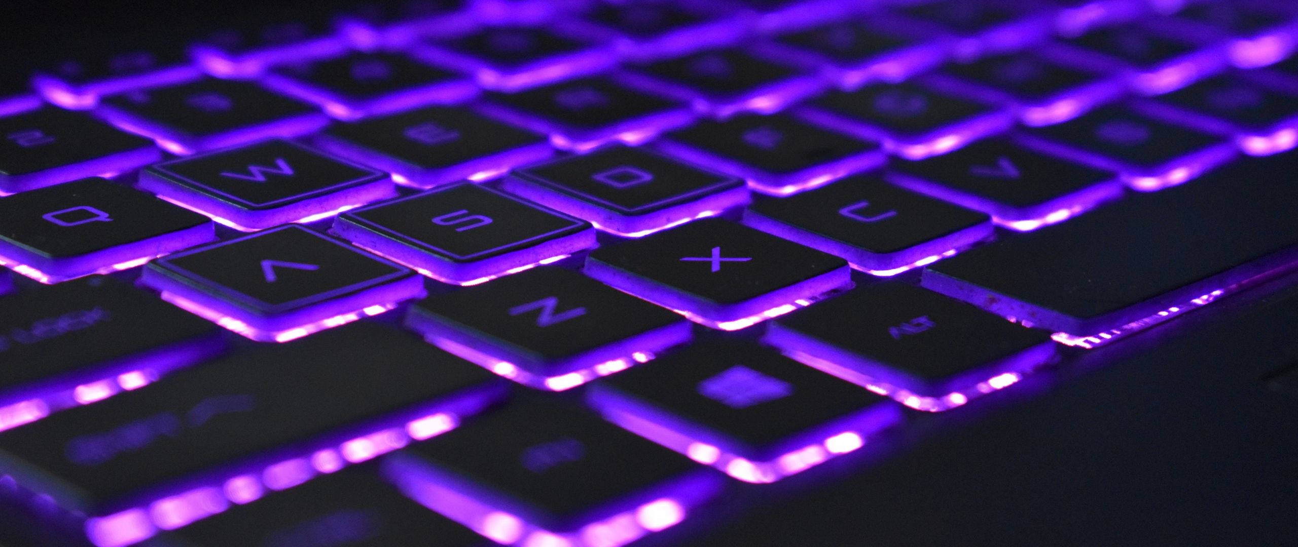 violet neon light computer keyboard, black keyboard, vibrant purple backlighting, 2K Desktop Wallpaper