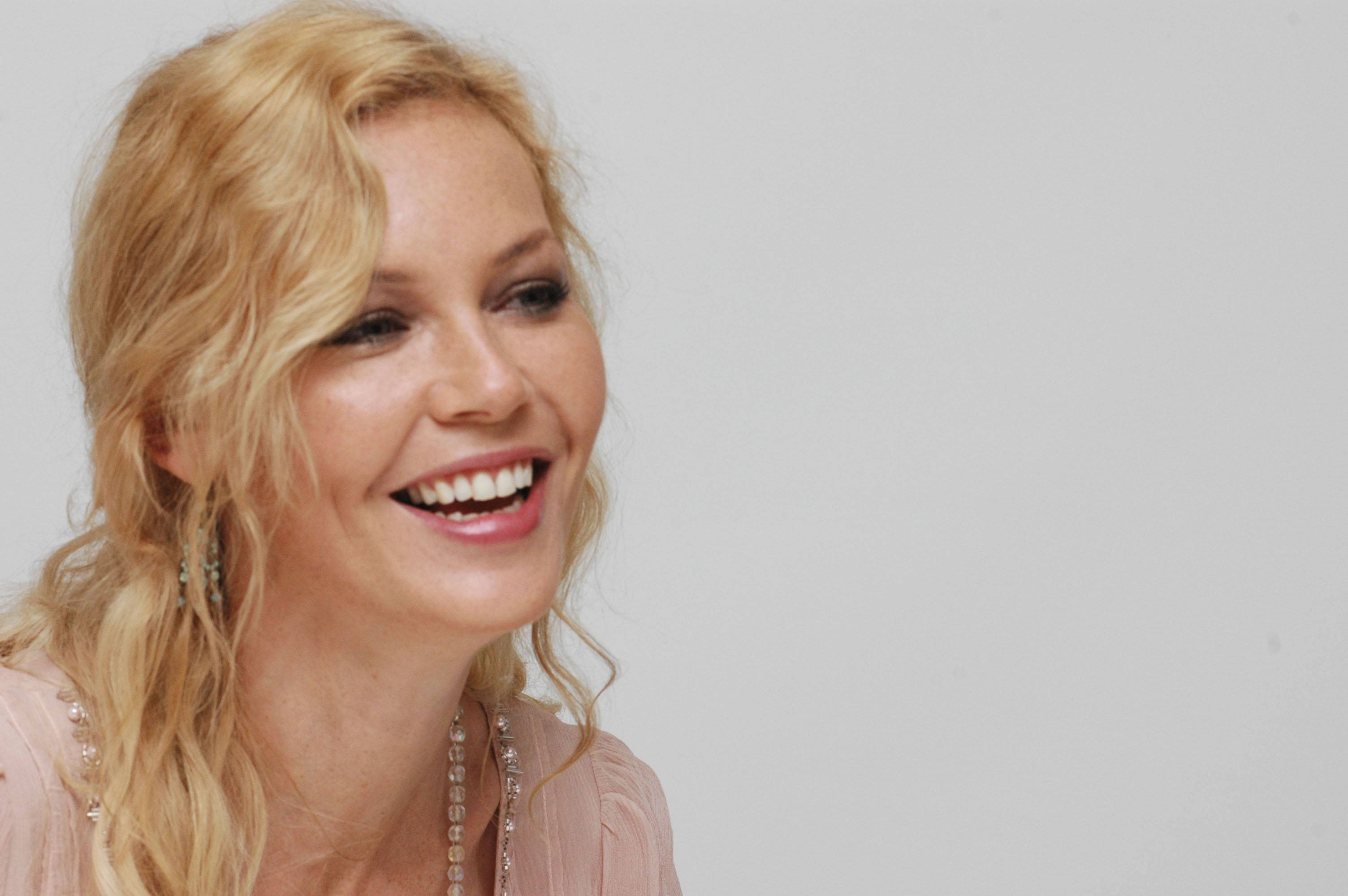 Connie Nielsen, blonde hair, light pink top, 2K Desktop Wallpaper
