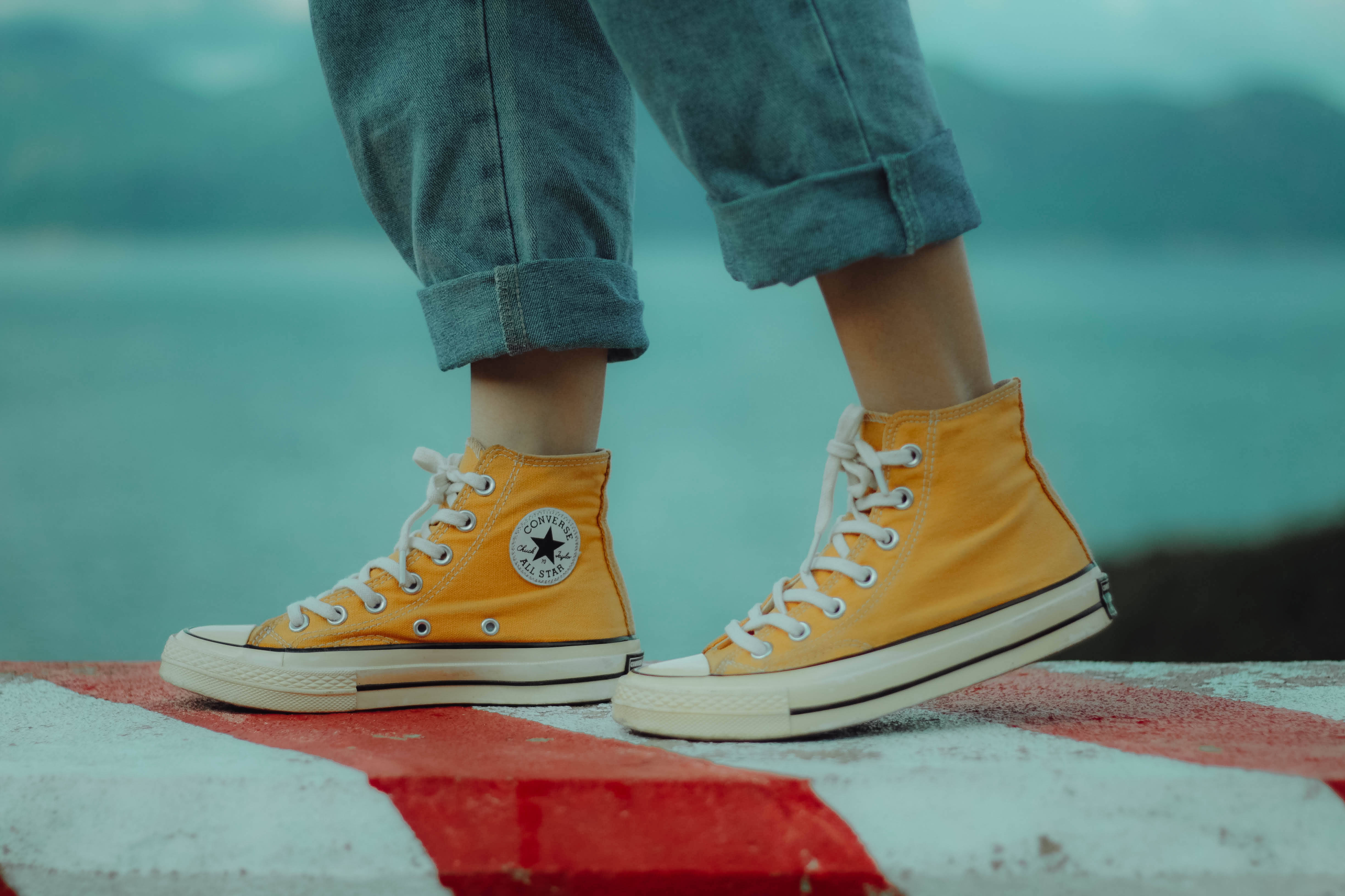 yellow high-top sneakers, red and white striped surface, teal water background, 4K Desktop Wallpaper