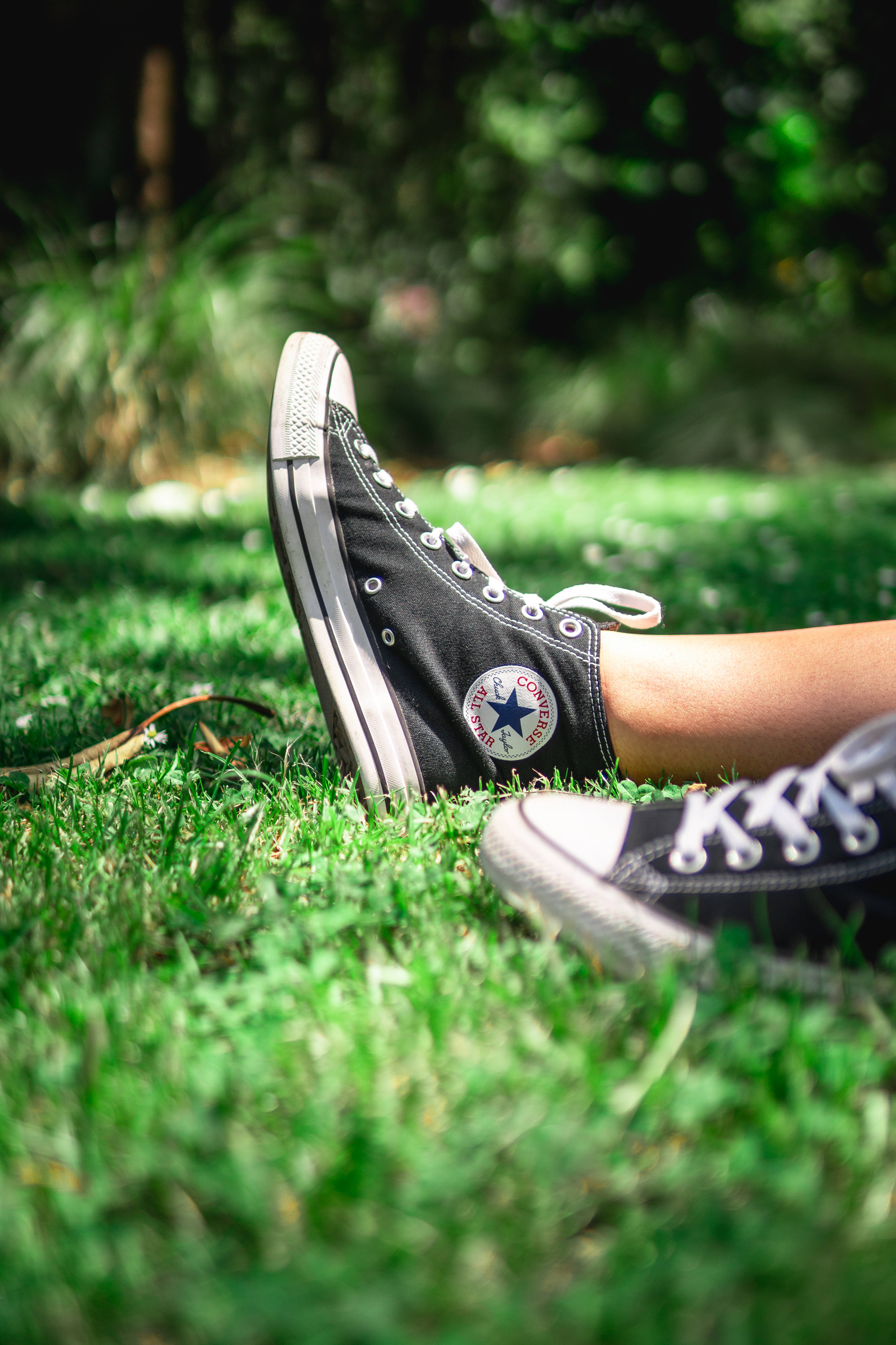 black Converse, vibrant green grass, bright sunlight, 5K Phone Wallpaper