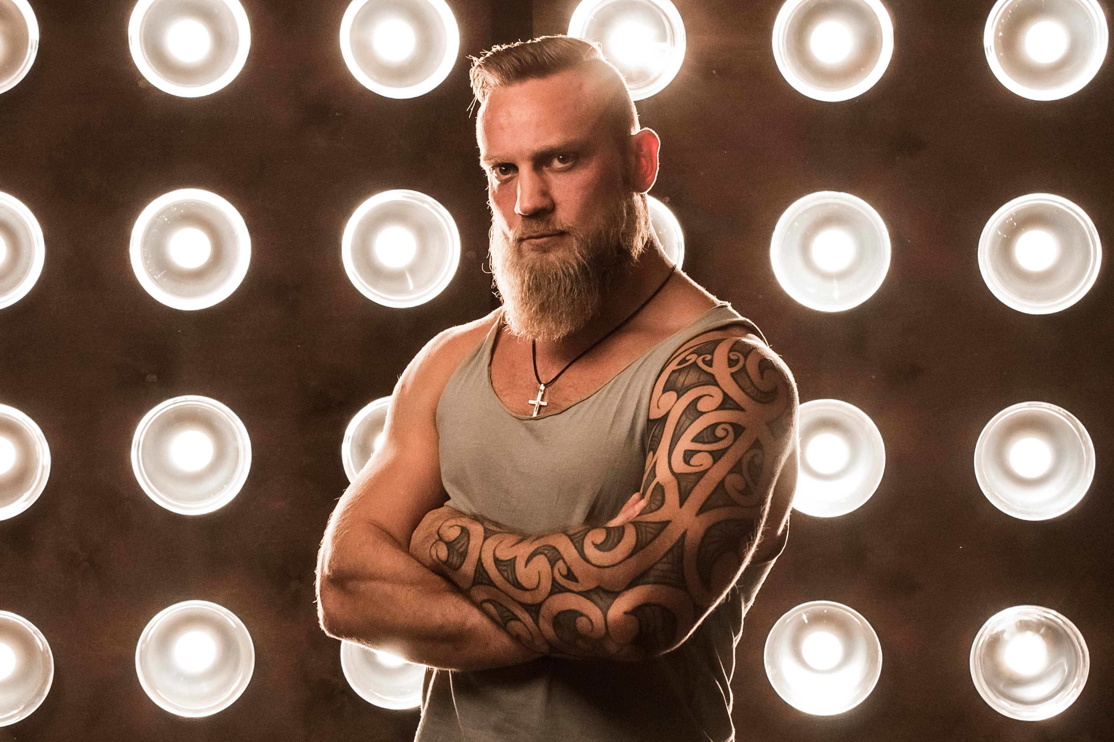 tattooed cool boy, tribal tattoos, glowing circular stage lights, 2K Desktop Wallpaper