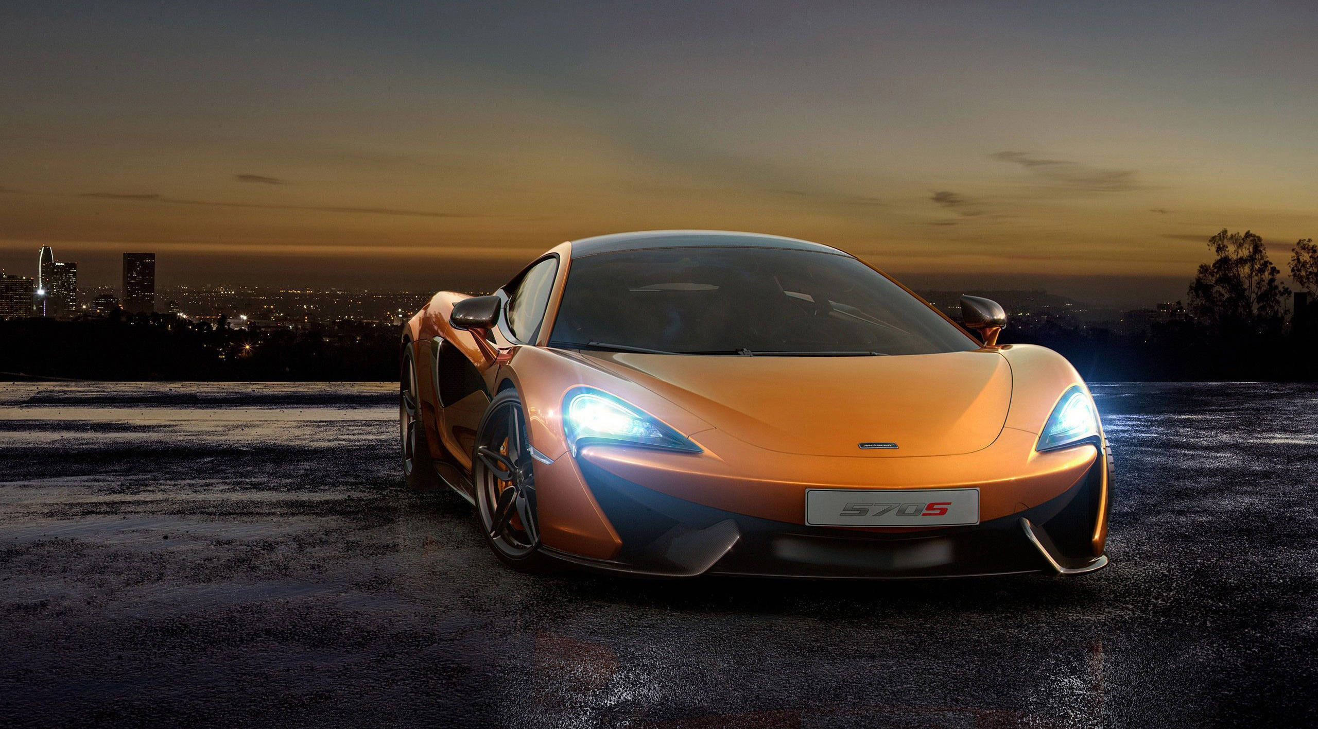 orange McLaren 570S, glowing headlights, wet rooftop, 2K Desktop Wallpaper