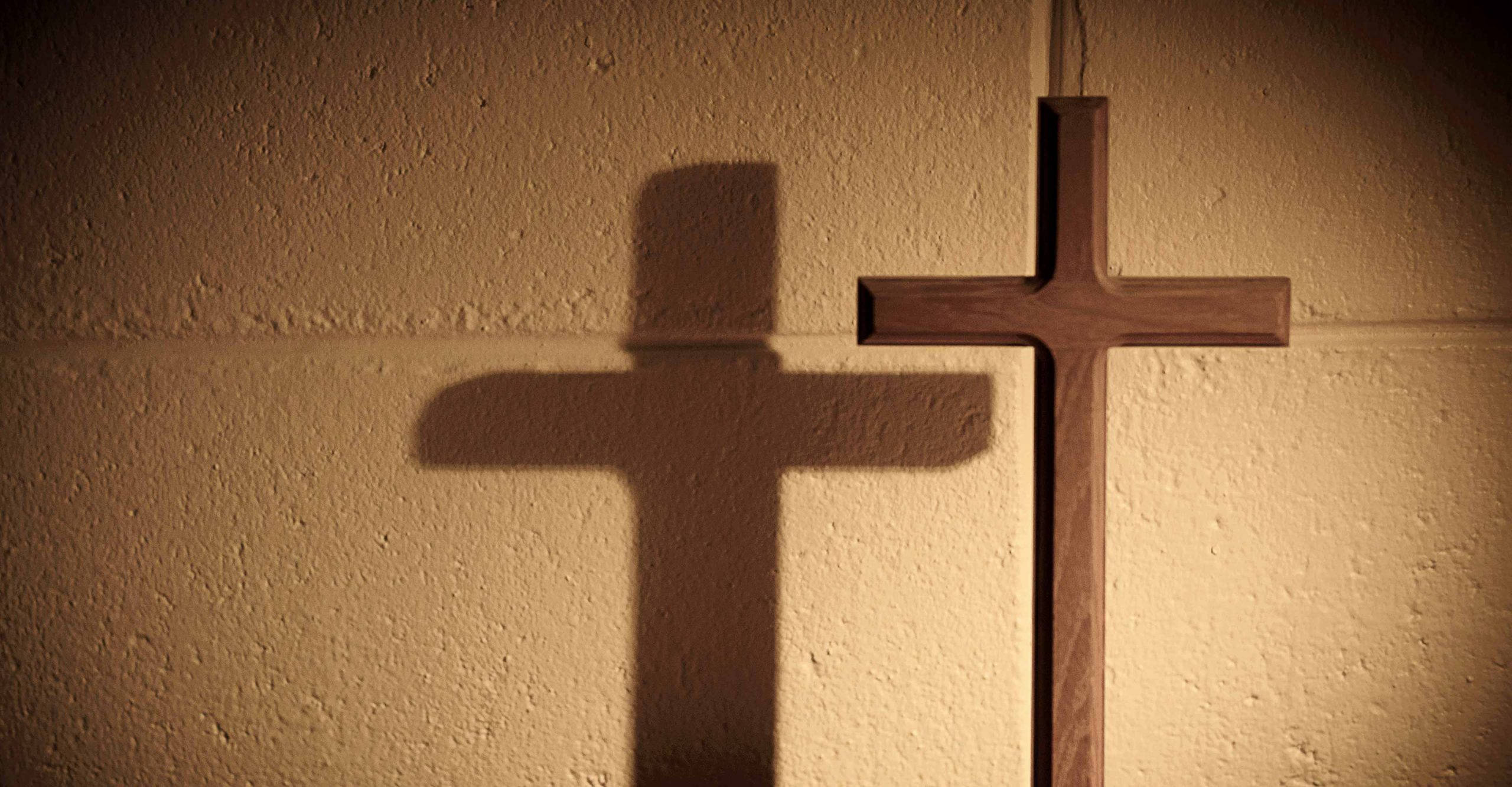 wooden cross, beige wall, warm directional lighting, 2K Desktop Wallpaper