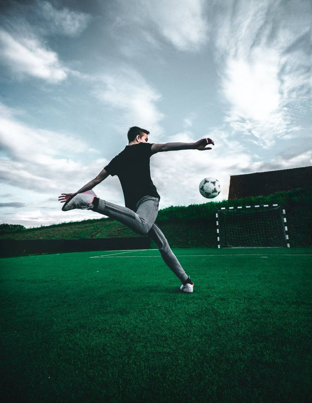 football player, kicking ball, vibrant green field, HD Phone Wallpaper