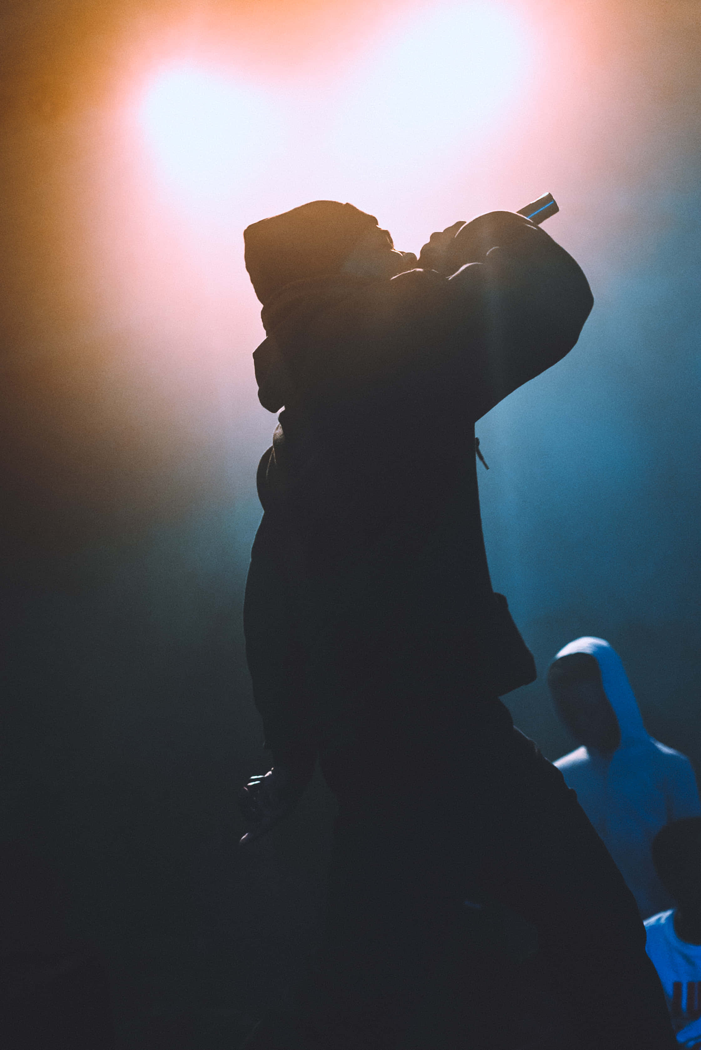 silhouetted rapper, dramatic stage lights, microphone, 2K Phone Wallpaper
