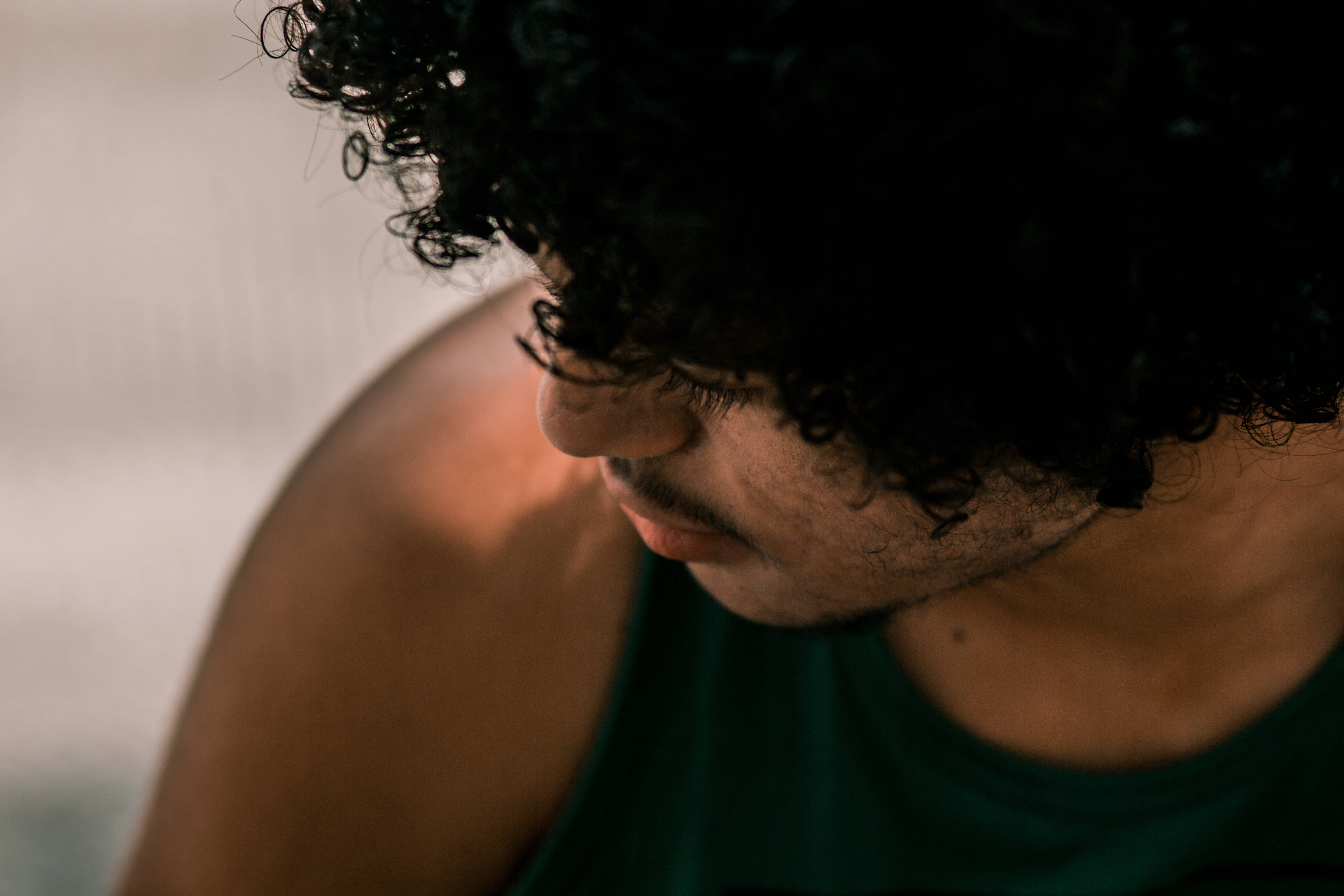 sad boy, dark curly hair, soft warm light, 5K Desktop Wallpaper