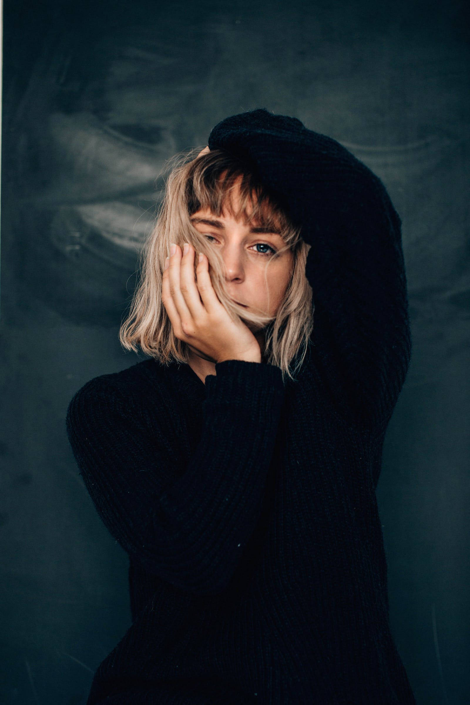 blonde hair, black hooded sweater, dark textured backdrop, Full HD Phone Wallpaper
