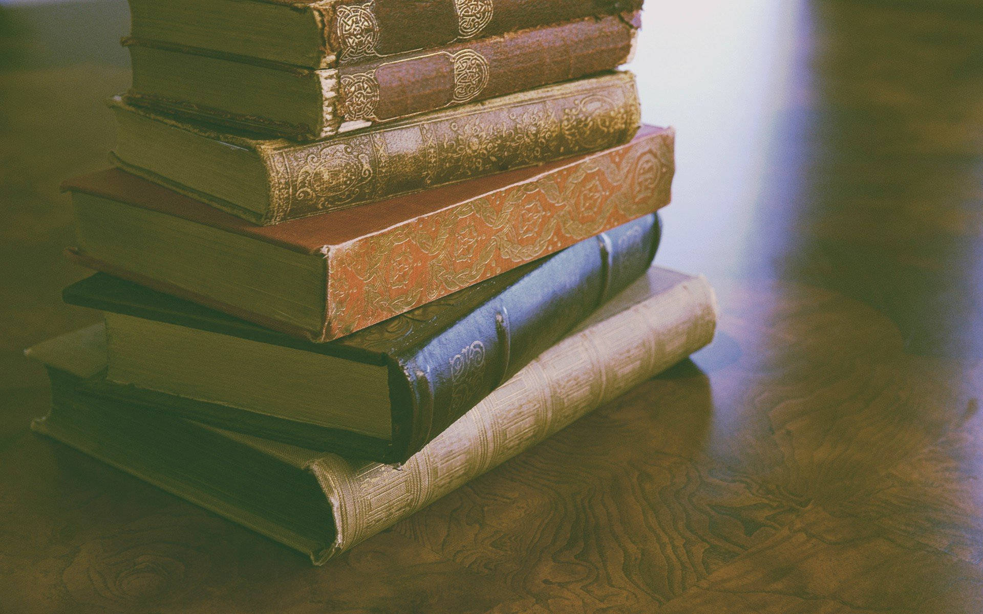 vintage leather-bound books, ornate gold detailing, polished wooden surface, Full HD Desktop Wallpaper
