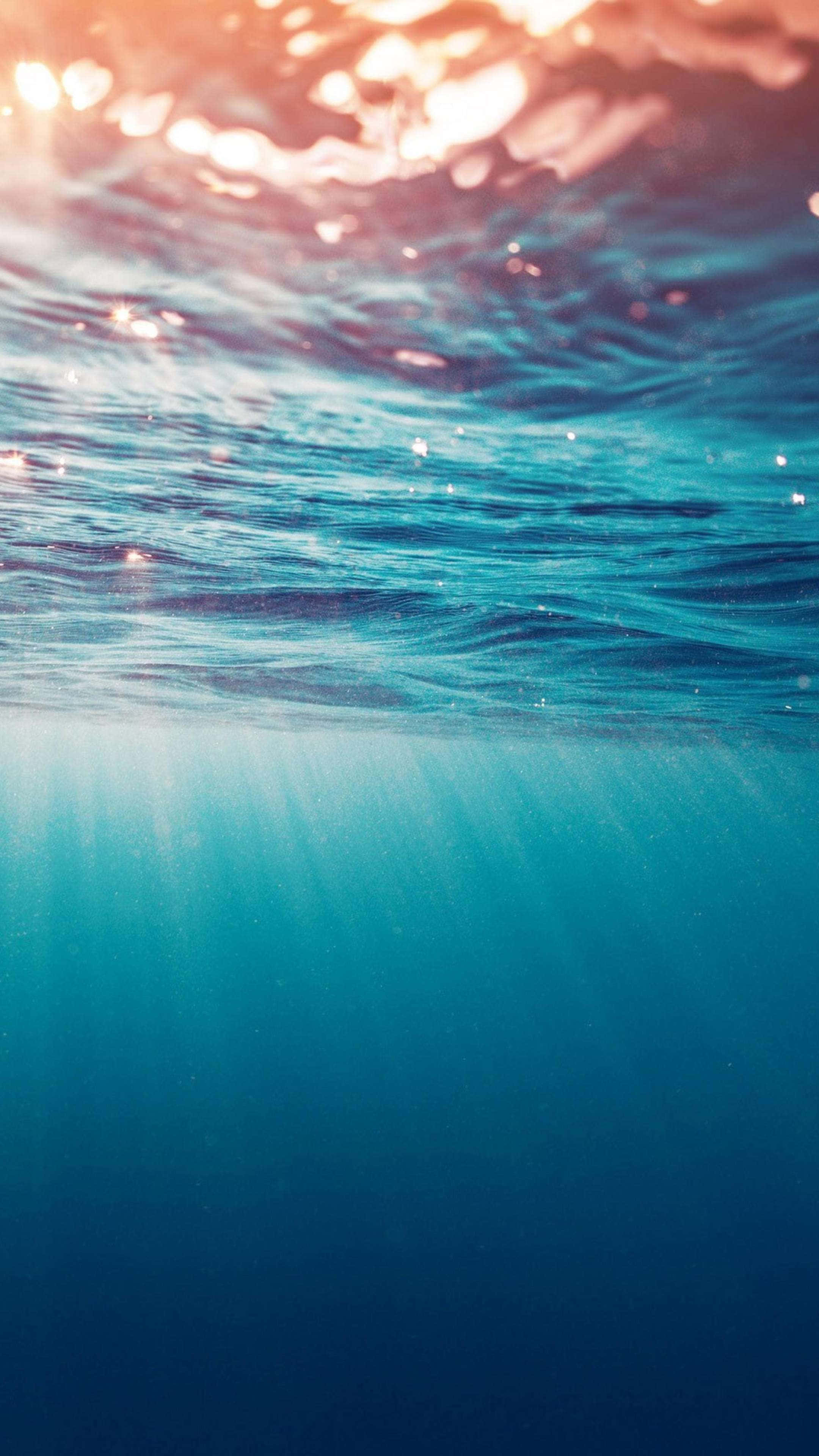 turquoise ocean waves, sunlight rays, underwater glow, 4K Phone Wallpaper