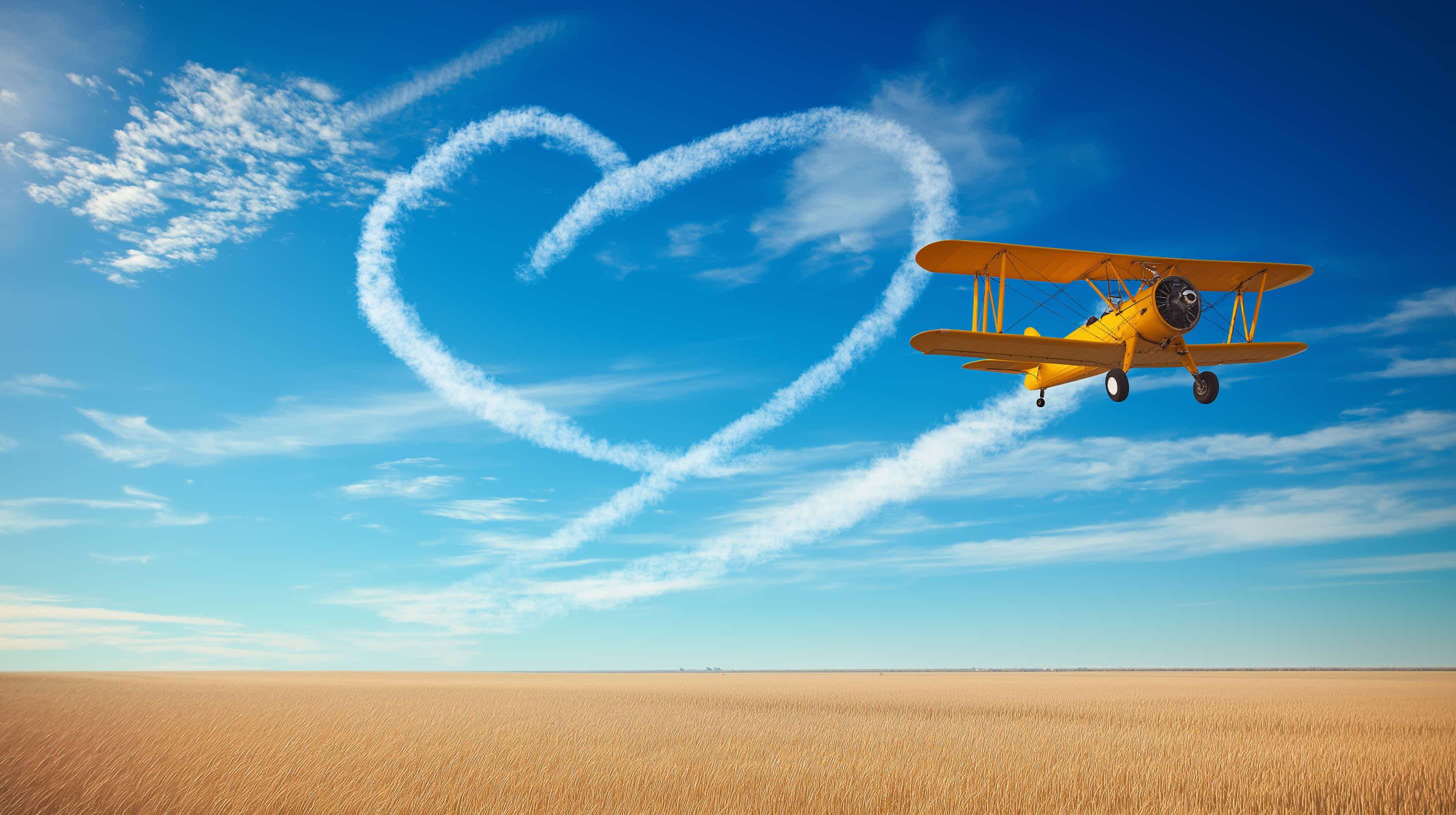 classic biplane, heart-shaped smoke trail, golden wheat field, 2K Desktop Wallpaper