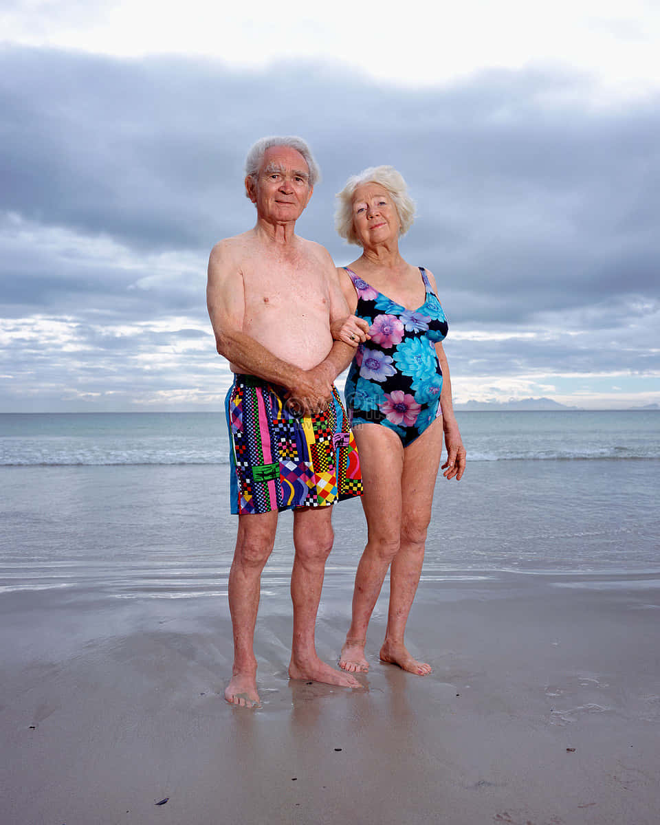 elderly couple, wet sandy beach, cloudy sky, SD Phone Wallpaper