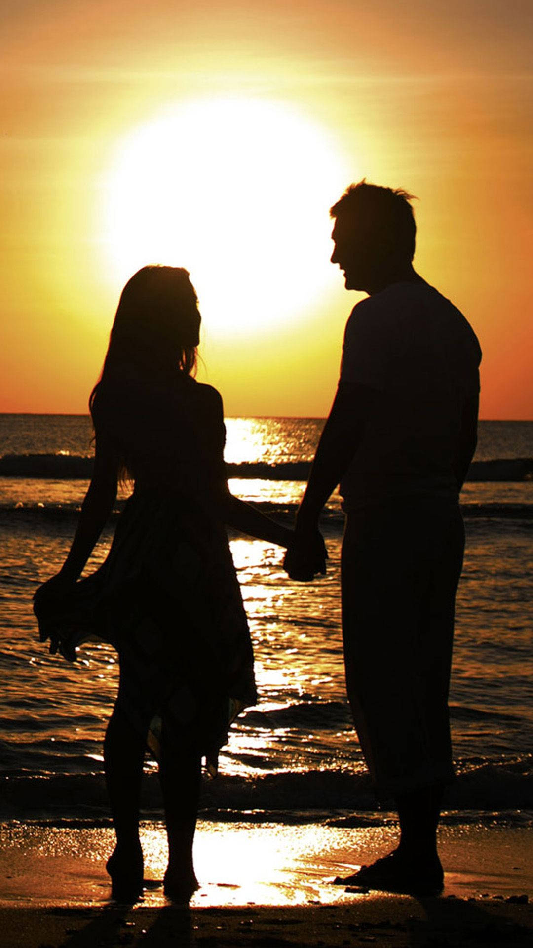 silhouetted couple, golden sun, ocean horizon, Full HD Phone Wallpaper