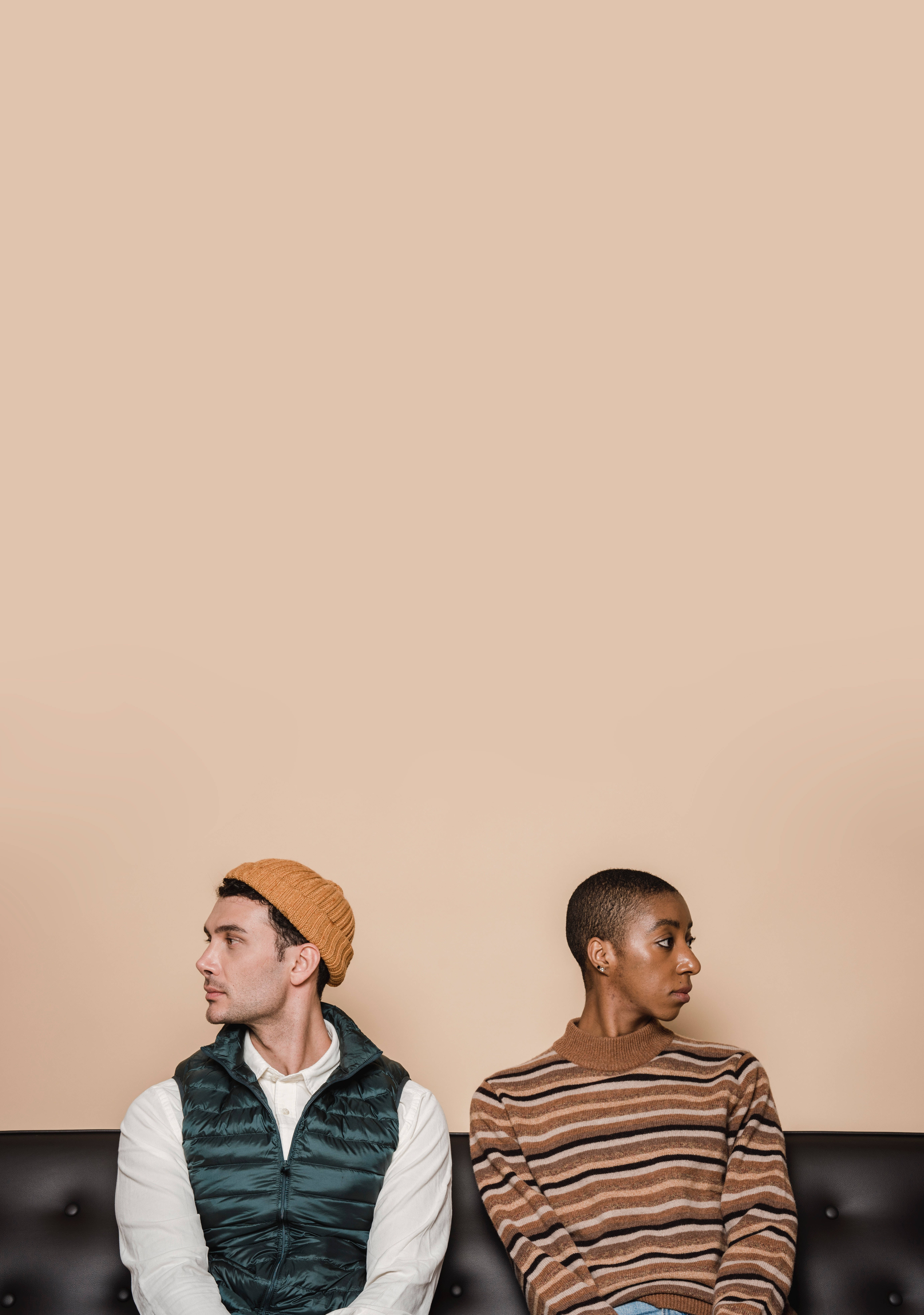black leather couch, solid beige wall, quiet tension, 8K Phone Wallpaper