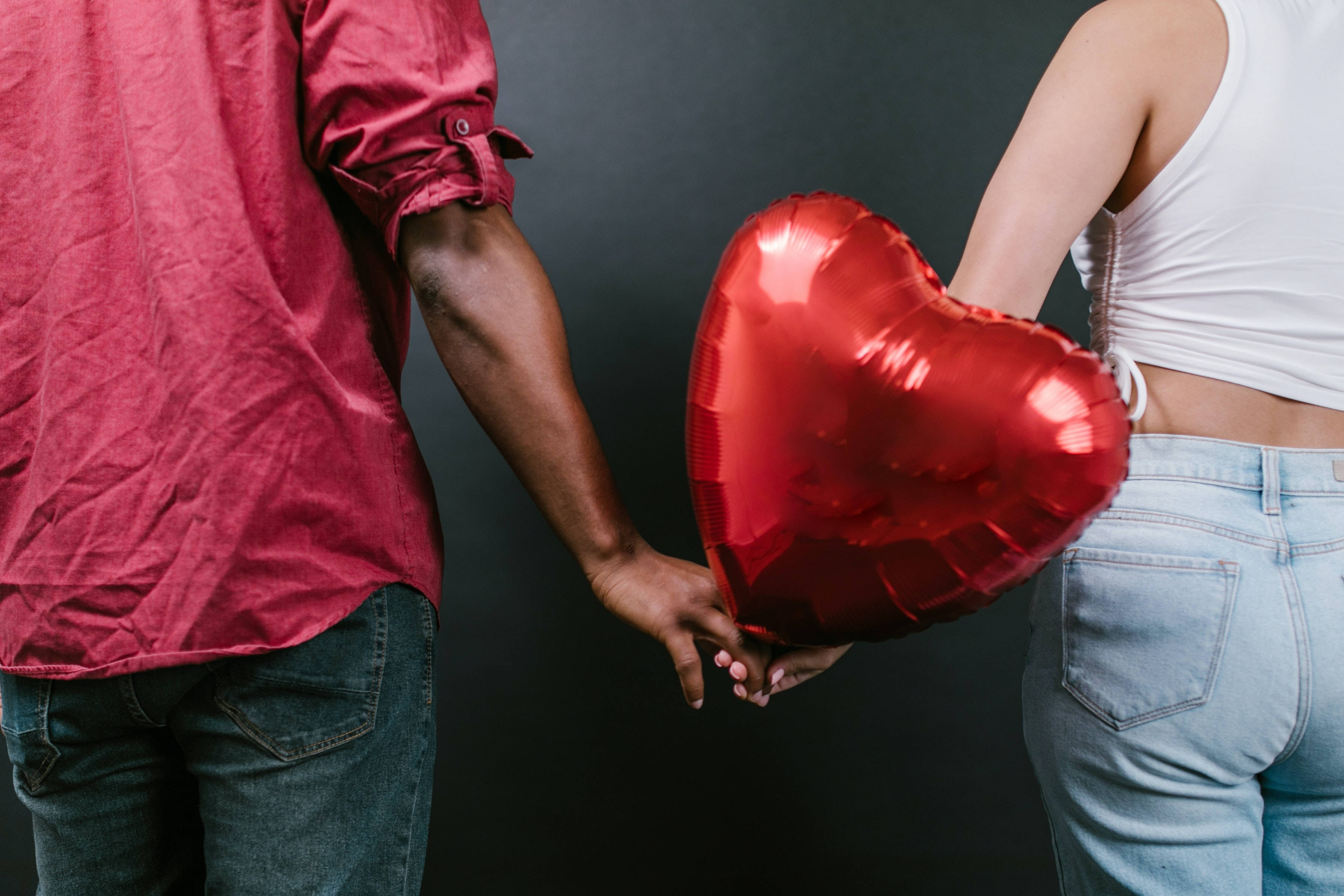 couple hands, shiny red heart balloon, dark backdrop, 2K Desktop Wallpaper
