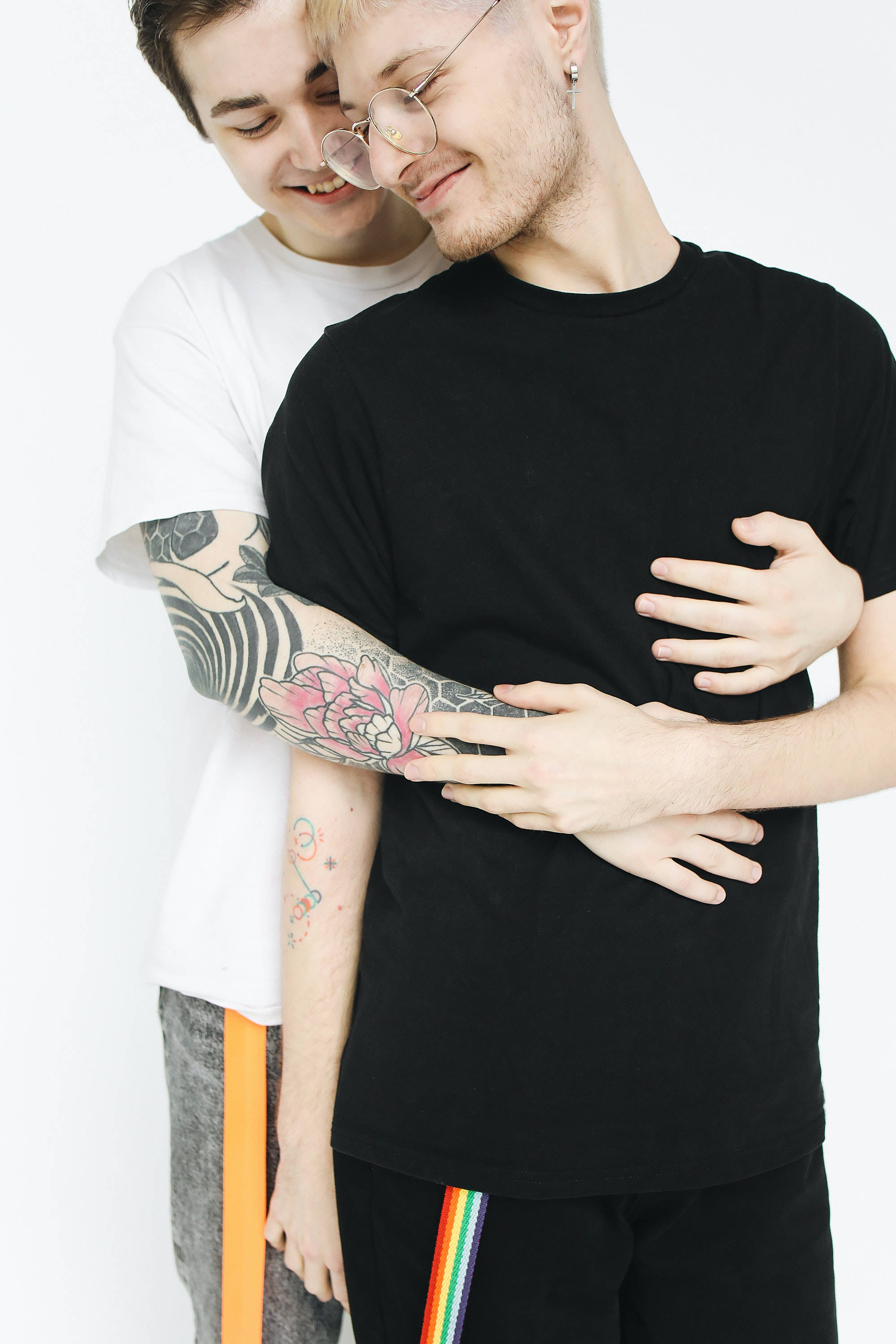 gay men, hugging from behind, colorful tattooed arm, 2K Phone Wallpaper